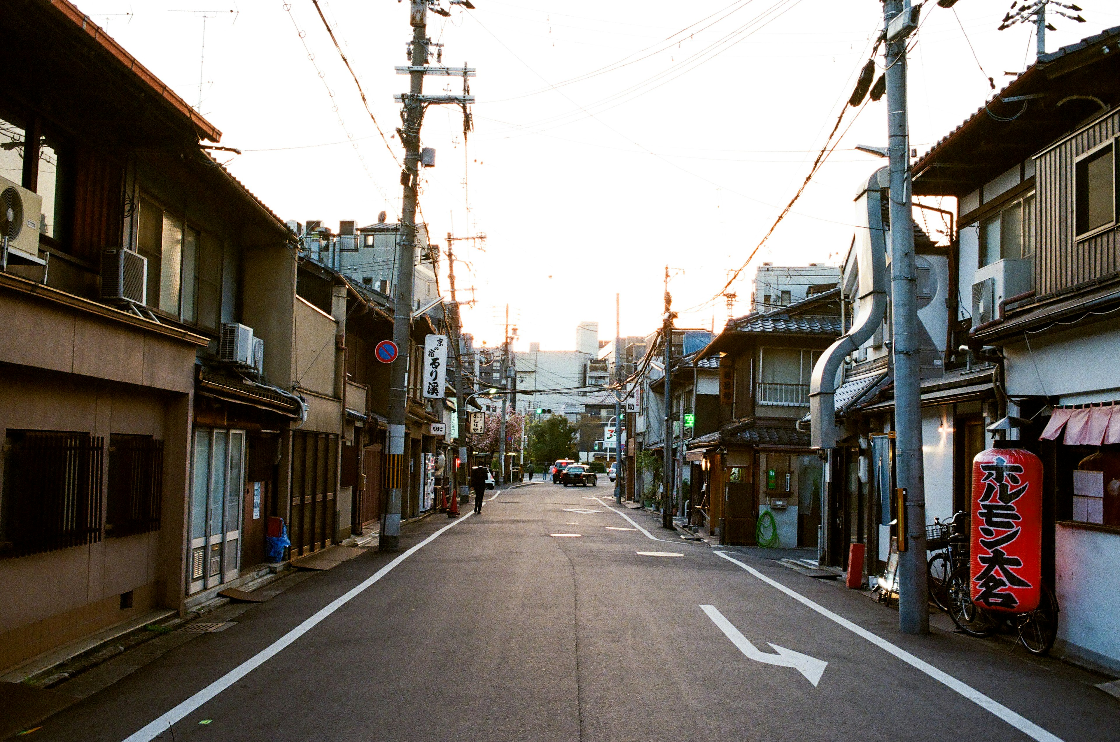 Quiet street with residential and commercial buildings, morning light illuminating the scene