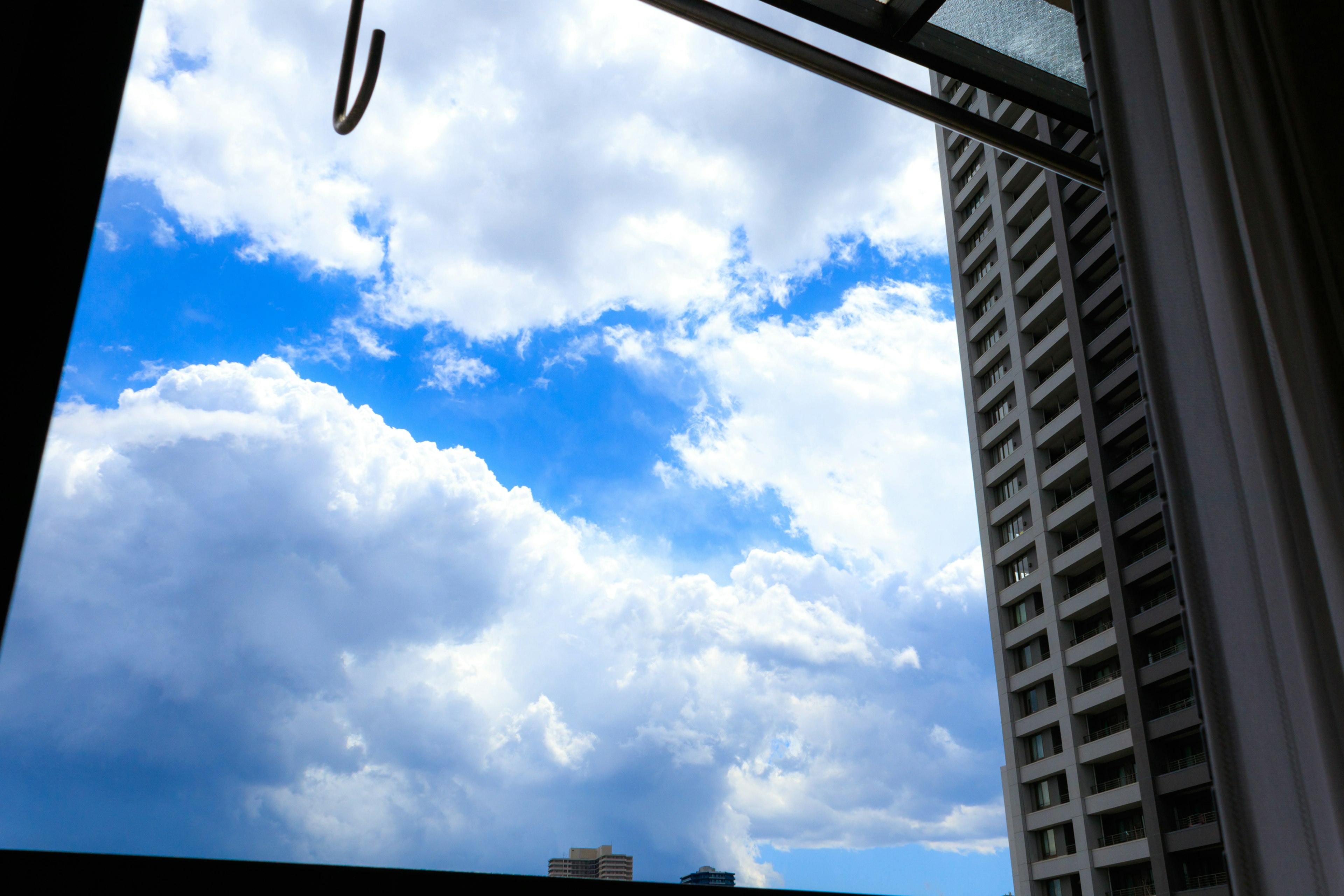 Vista del cielo azul y nubes blancas desde una ventana