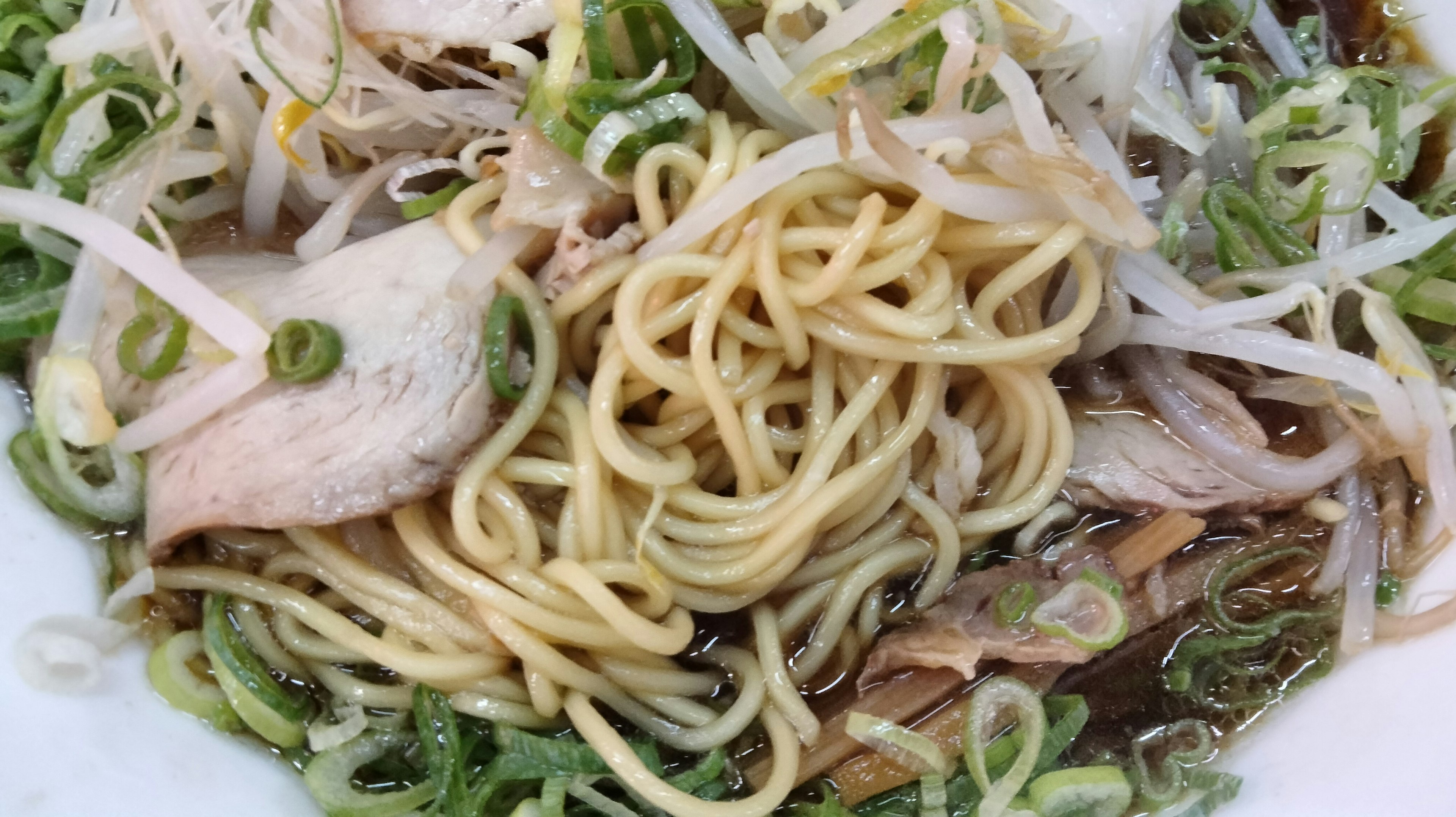 Ciotola di ramen con noodles sottili e guarnizioni di cipolla verde