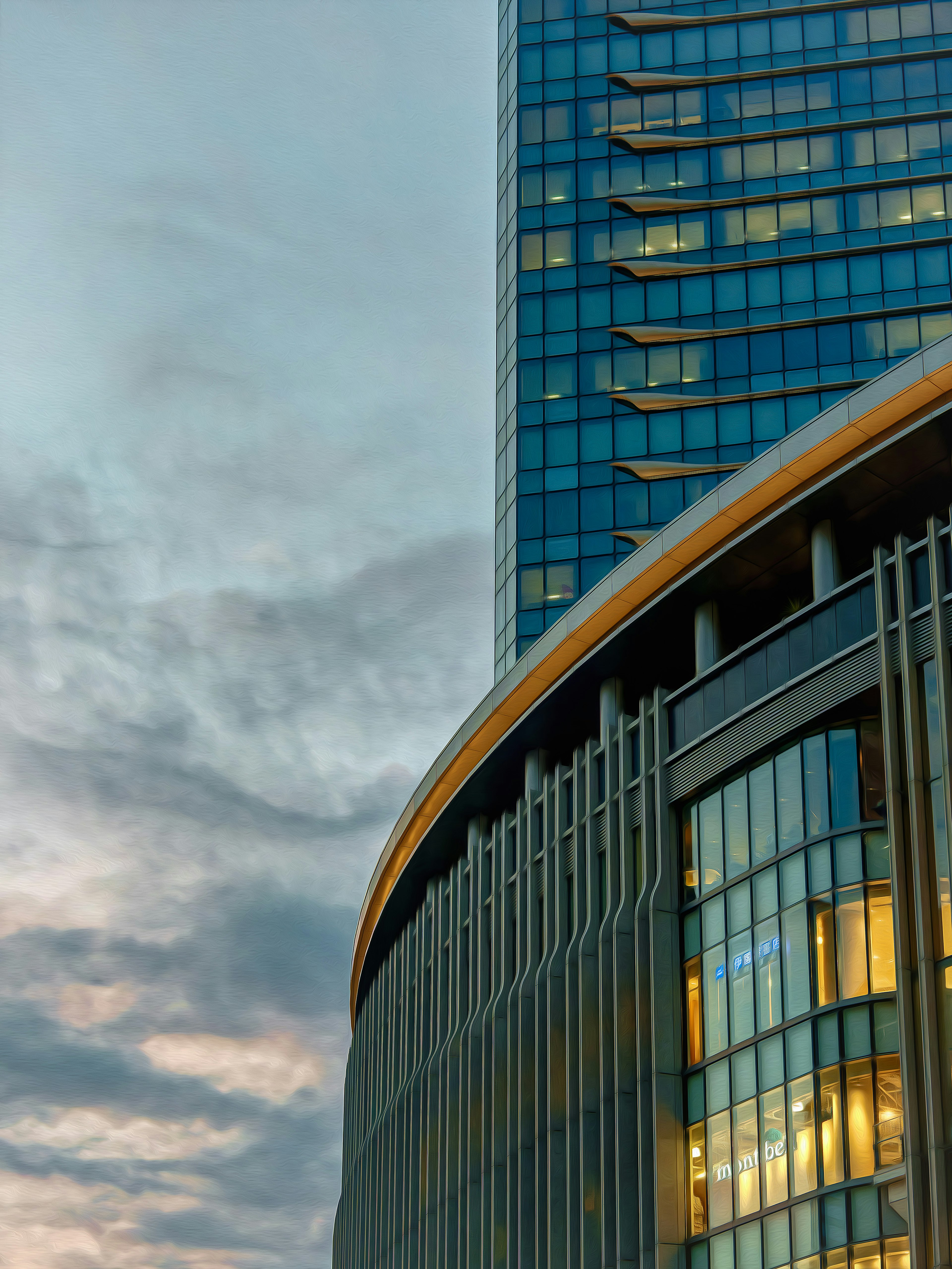 Modernes Gebäude mit gewölbtem Design bei Dämmerung, das Glas und beleuchtete Fenster zeigt