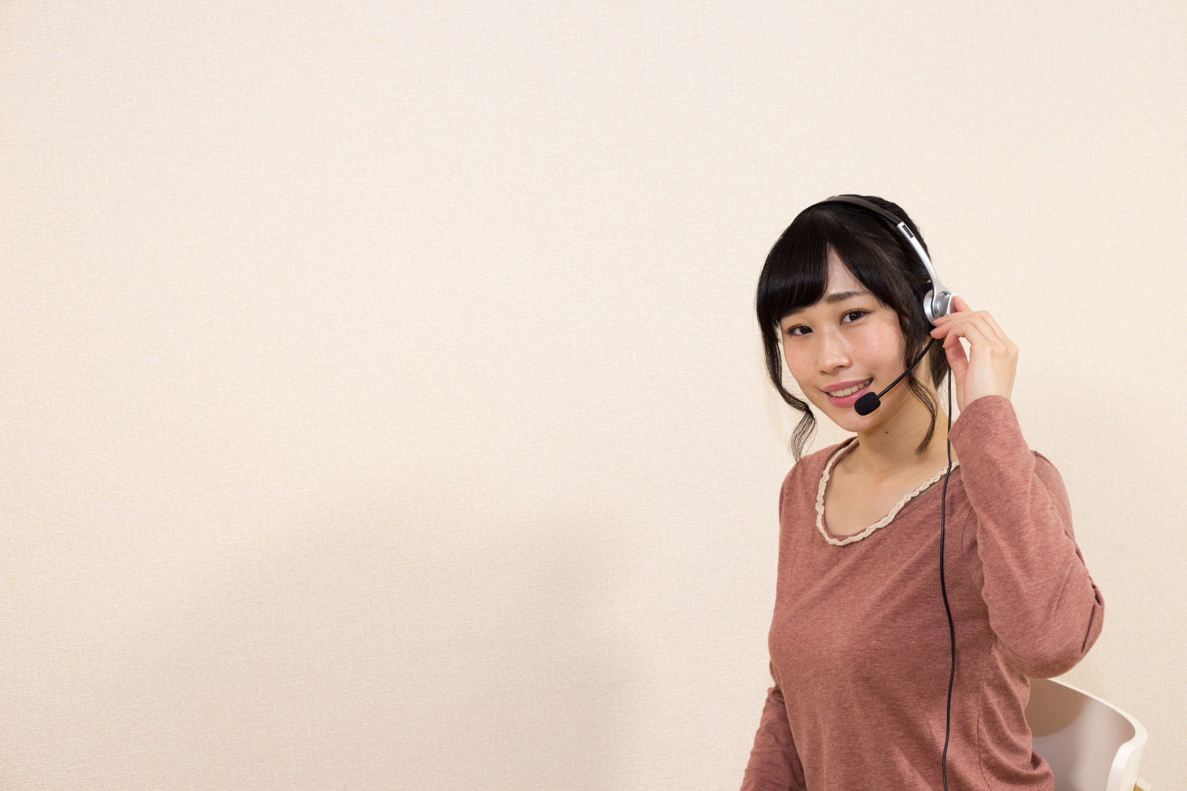 Una mujer con auriculares sonriendo a la cámara