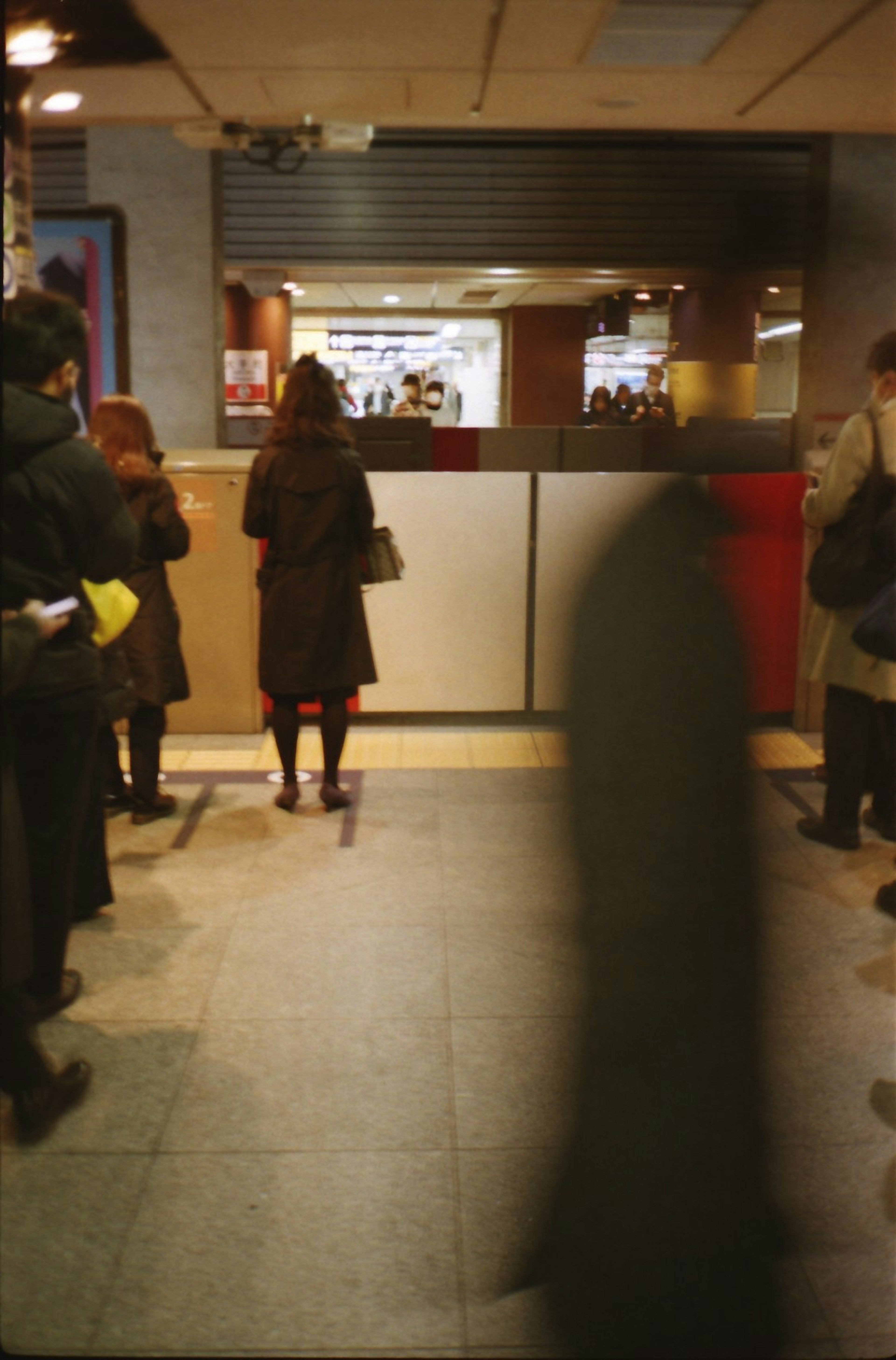 People waiting at a counter with a blurred figure passing by