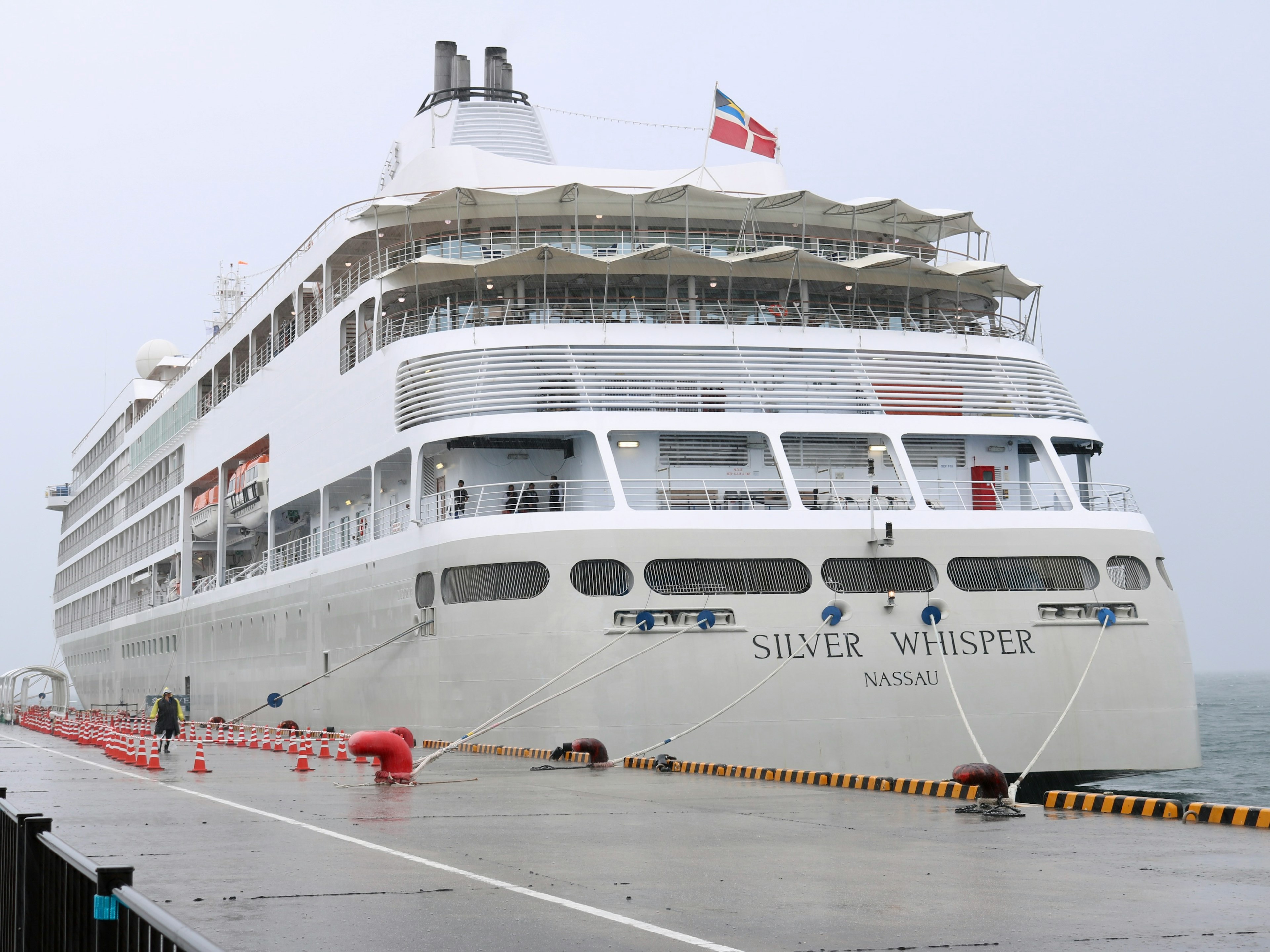 一艘大型白色郵輪在雨中停靠