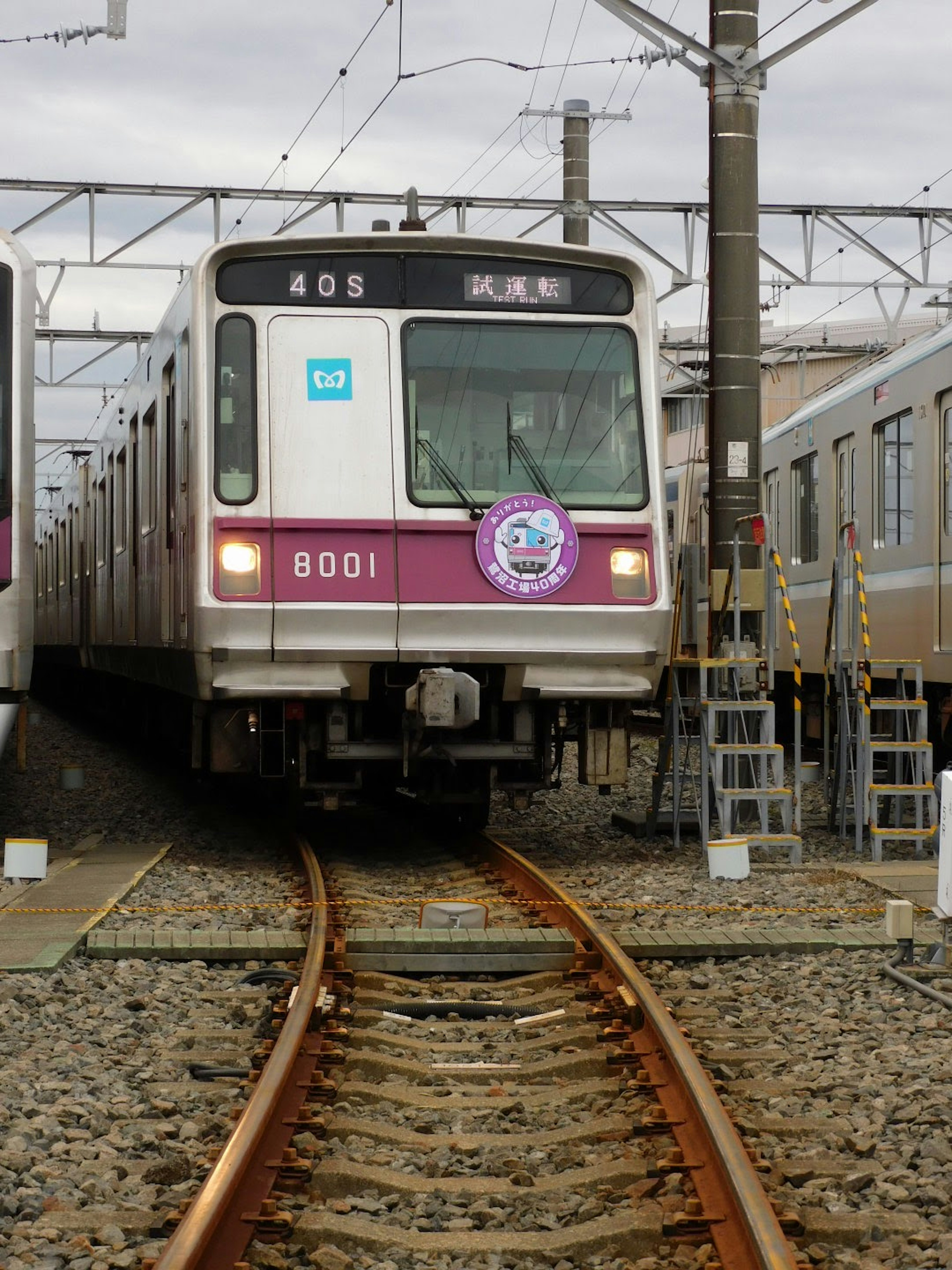 Kereta dengan garis ungu diparkir di rel