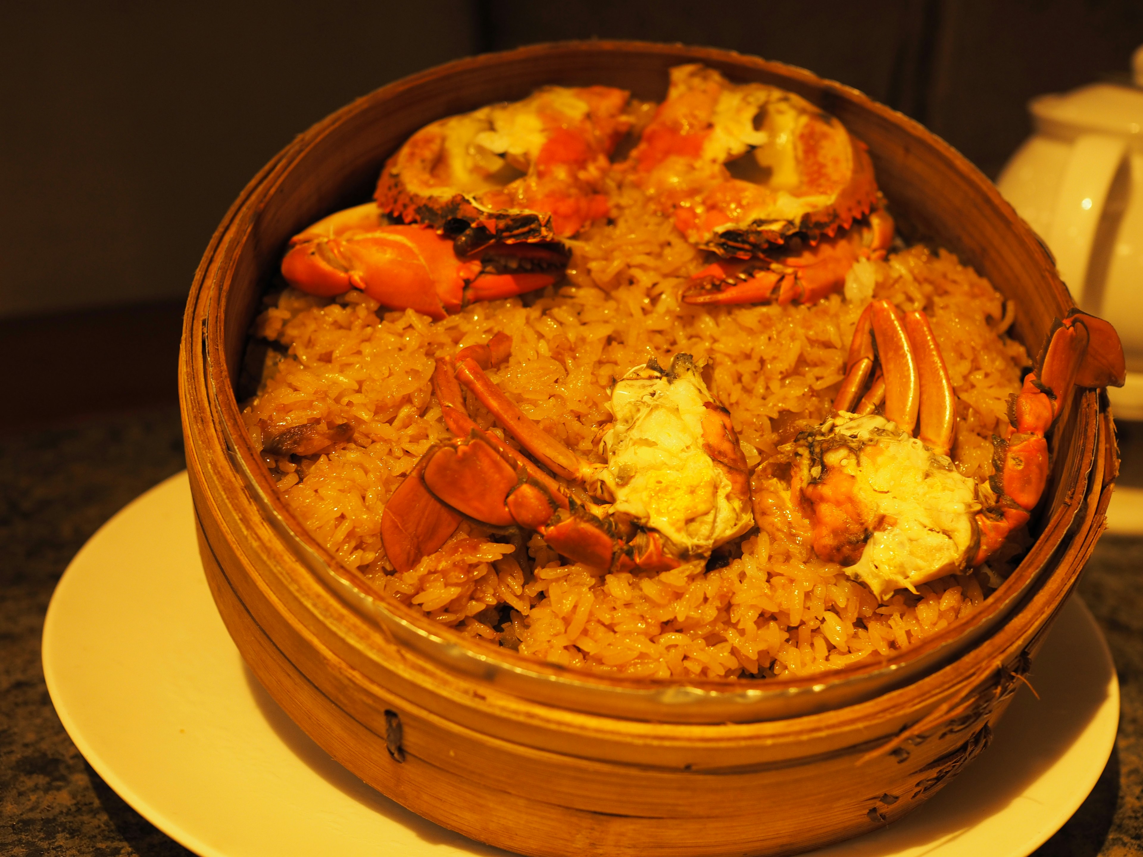 Plato de arroz al vapor con cangrejo en una vaporera de bambú