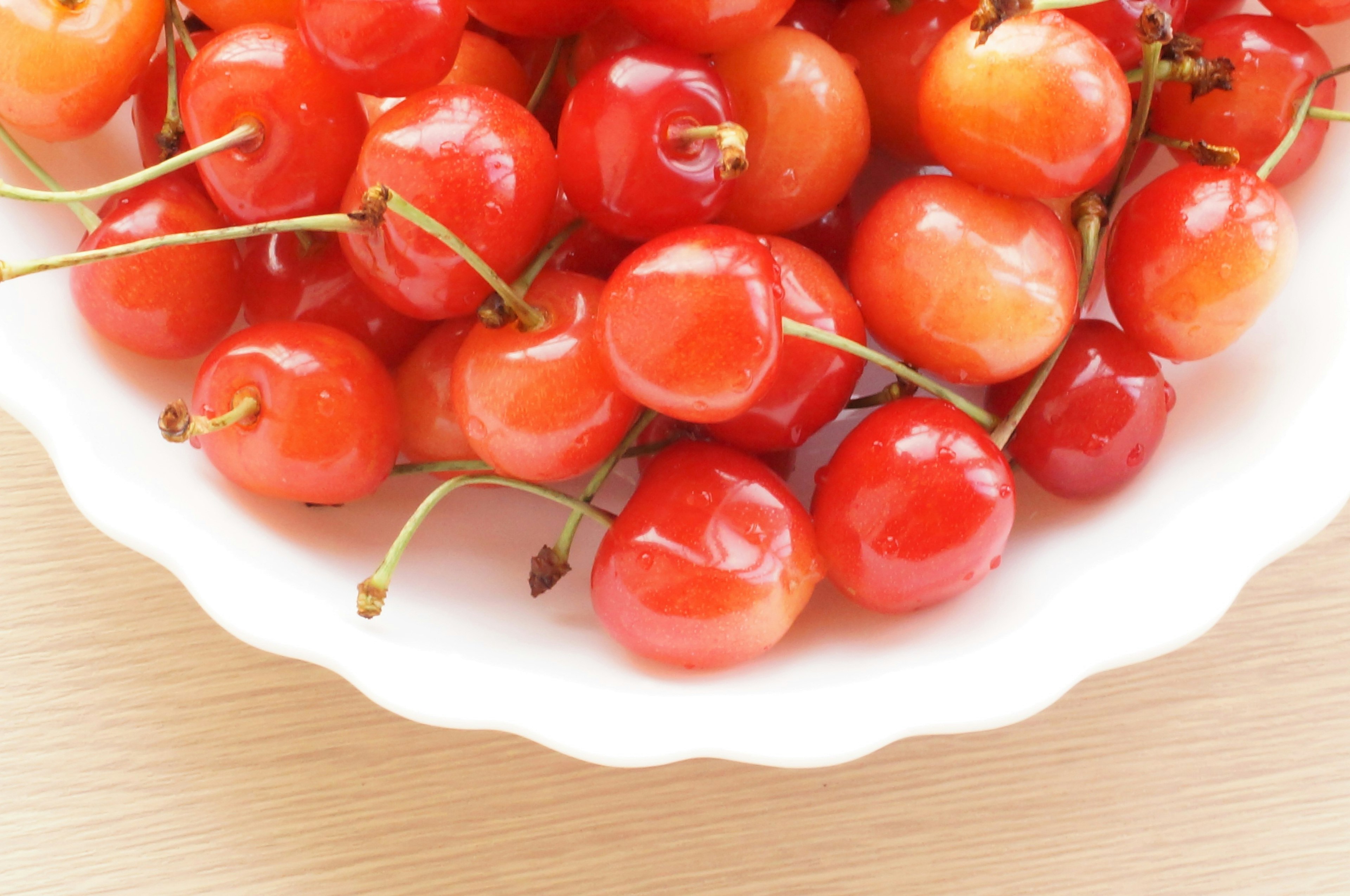 Vibrant red cherries in a white bowl