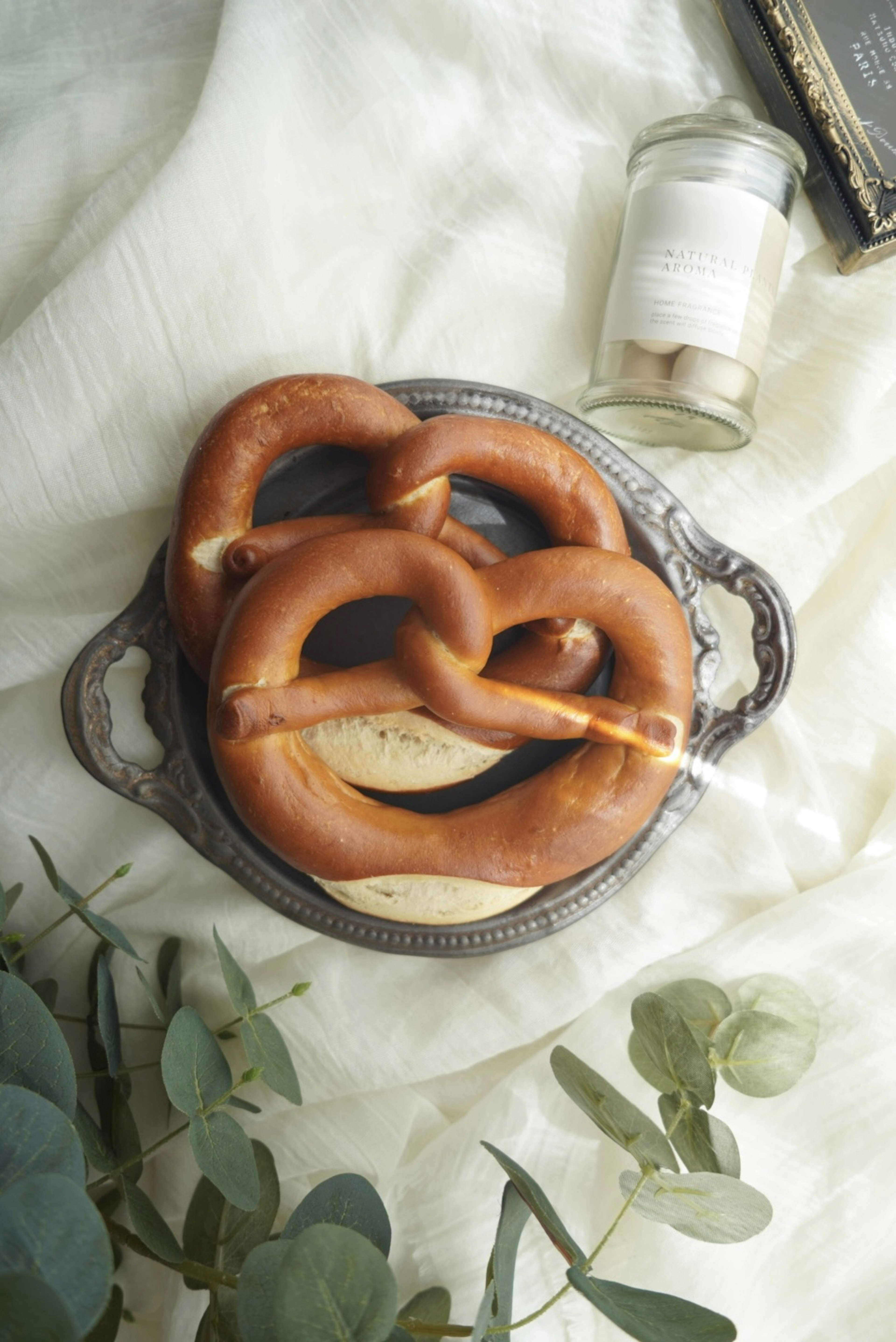 Una bella disposizione di pretzel su un piatto d'argento con foglie verdi