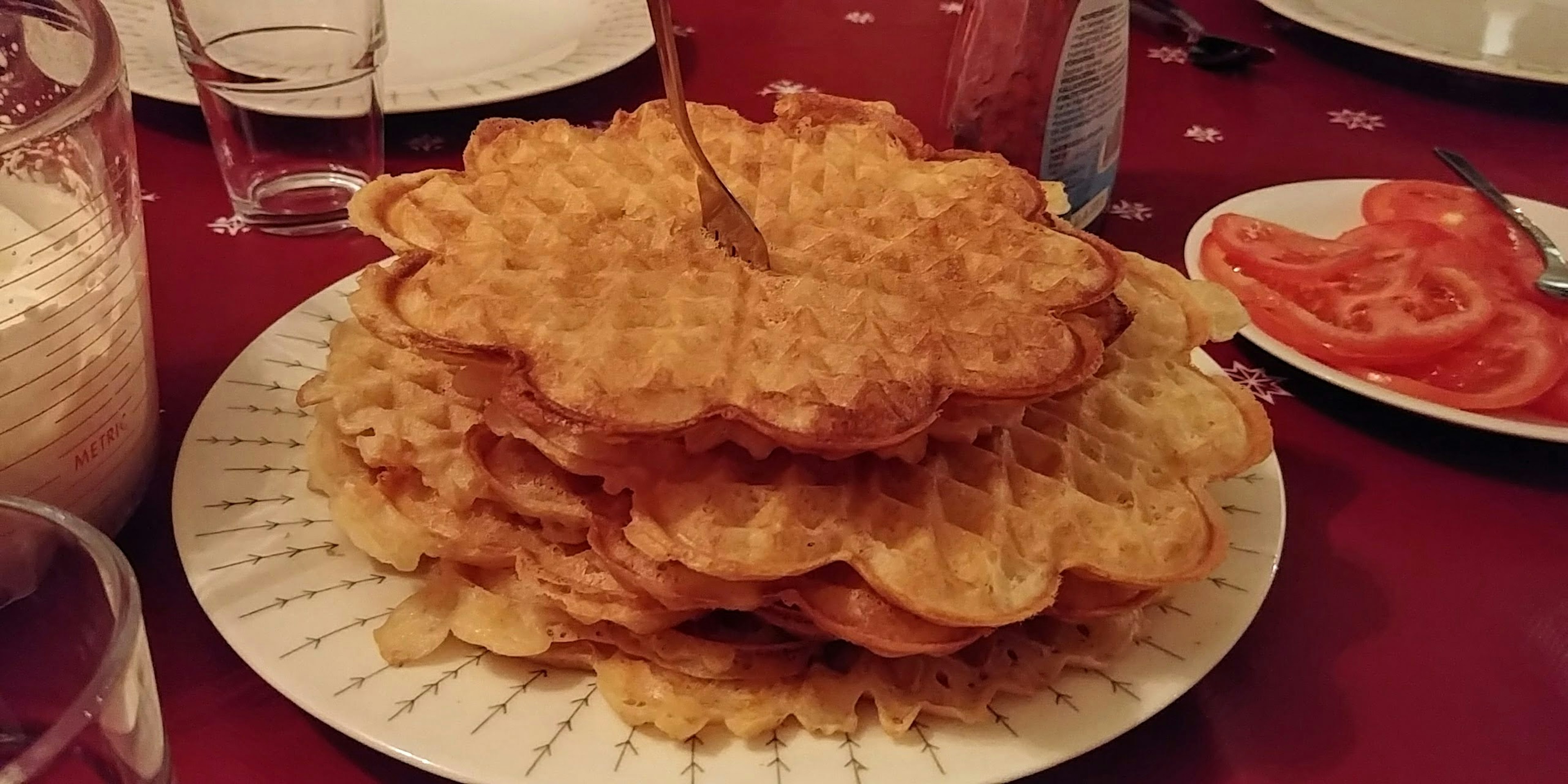 Tumpukan waffle disajikan di atas piring dengan garpu di atasnya