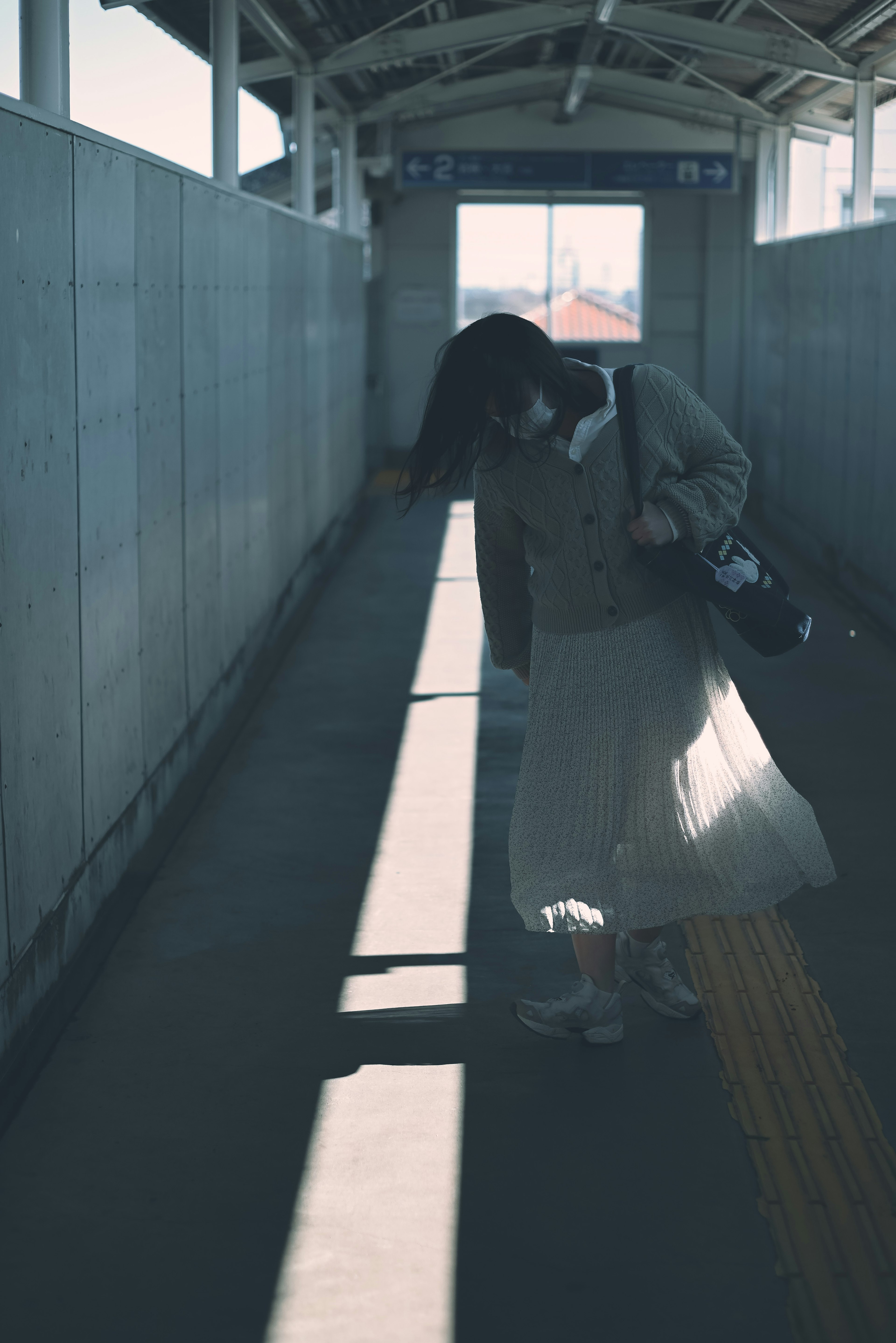 A woman in a skirt walking on a train platform