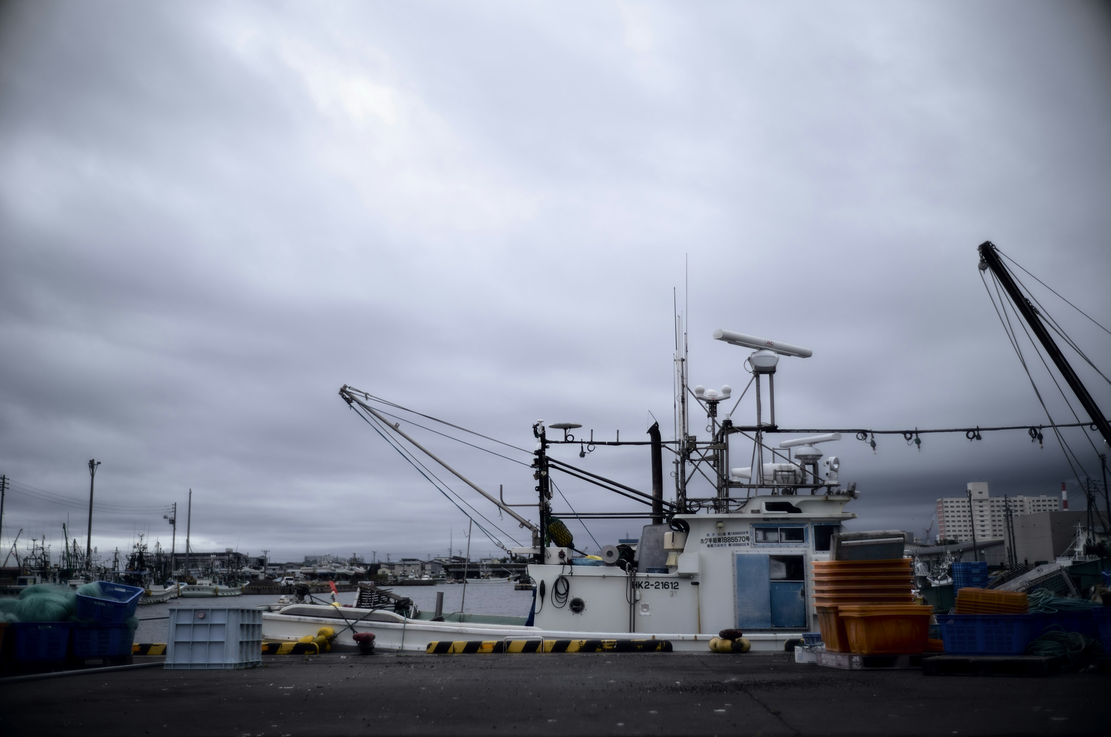 Fishing boat docked at the harbor under a cloudy sky