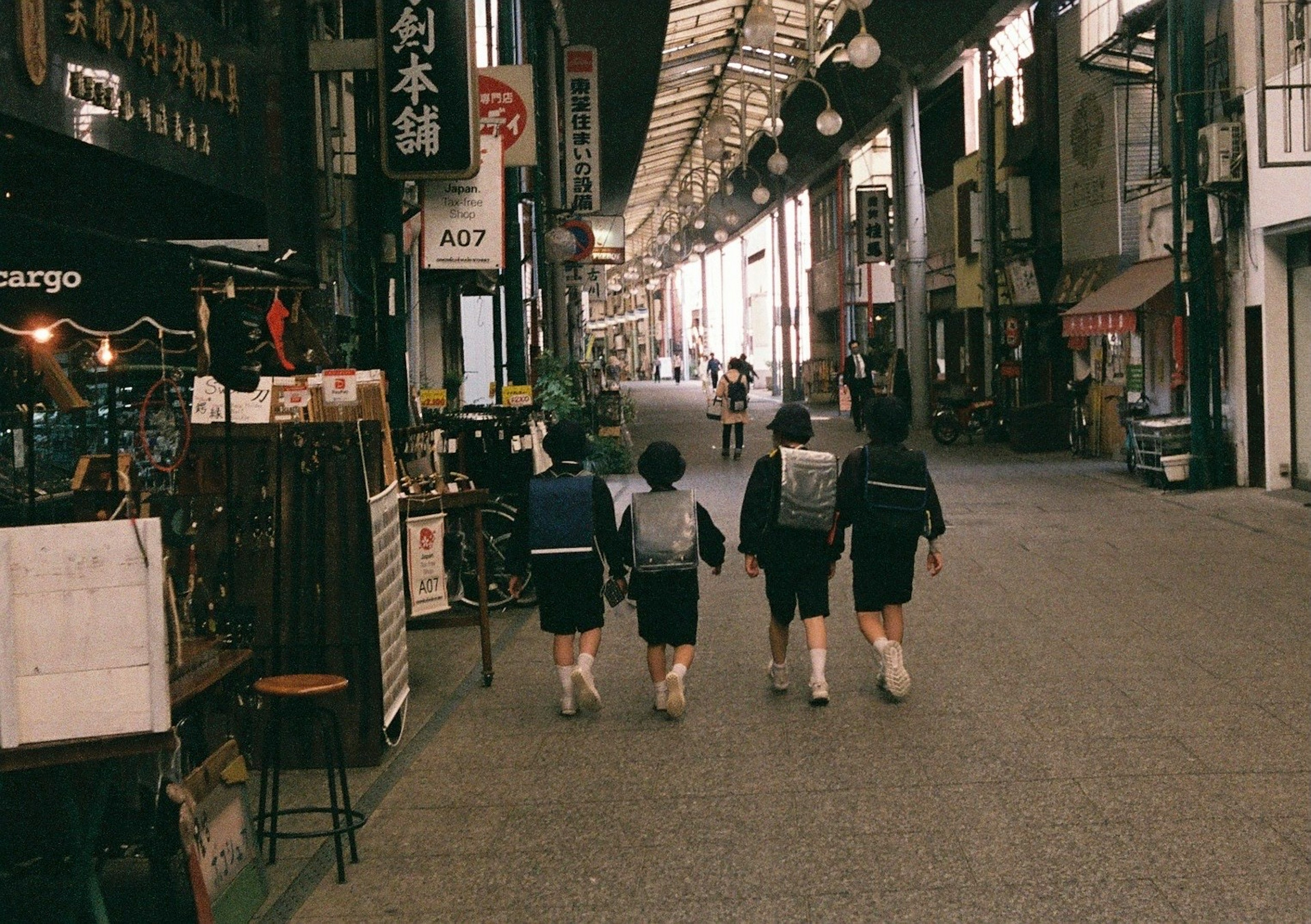 Estudiantes caminando en una calle comercial japonesa