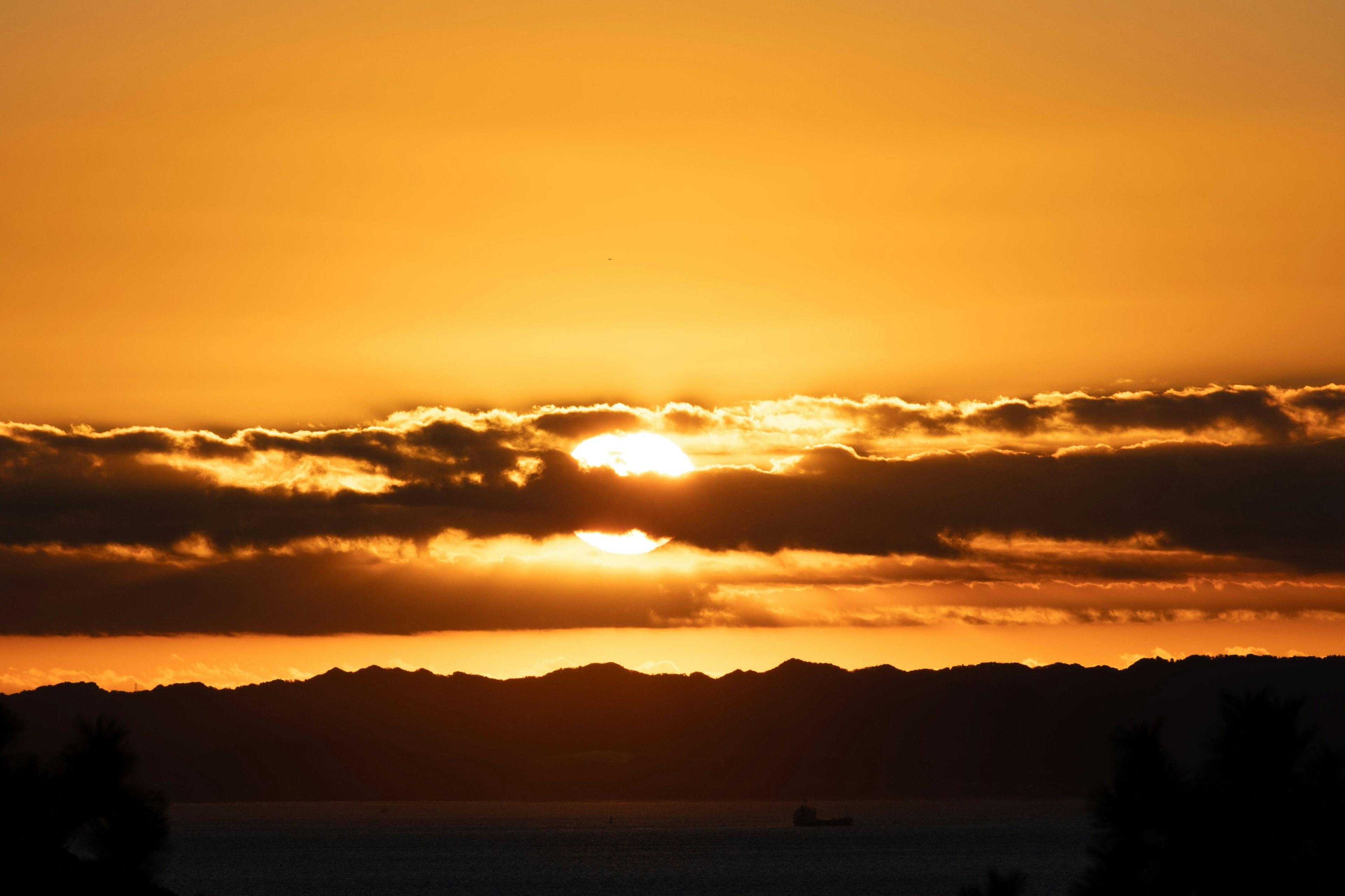 美しいオレンジ色の夕日が雲の間から昇る風景