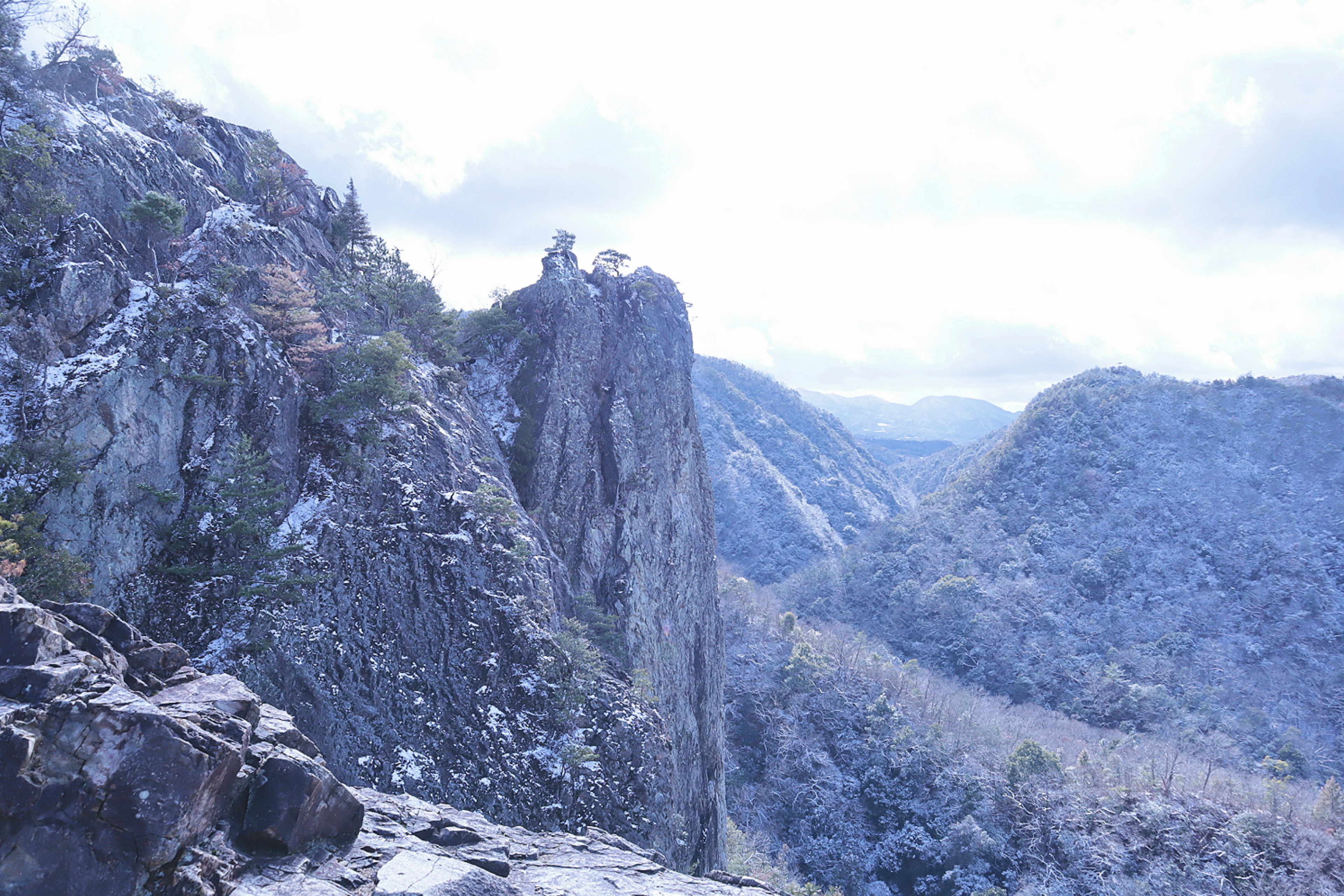 Vista escénica de montañas azules y acantilados rocosos