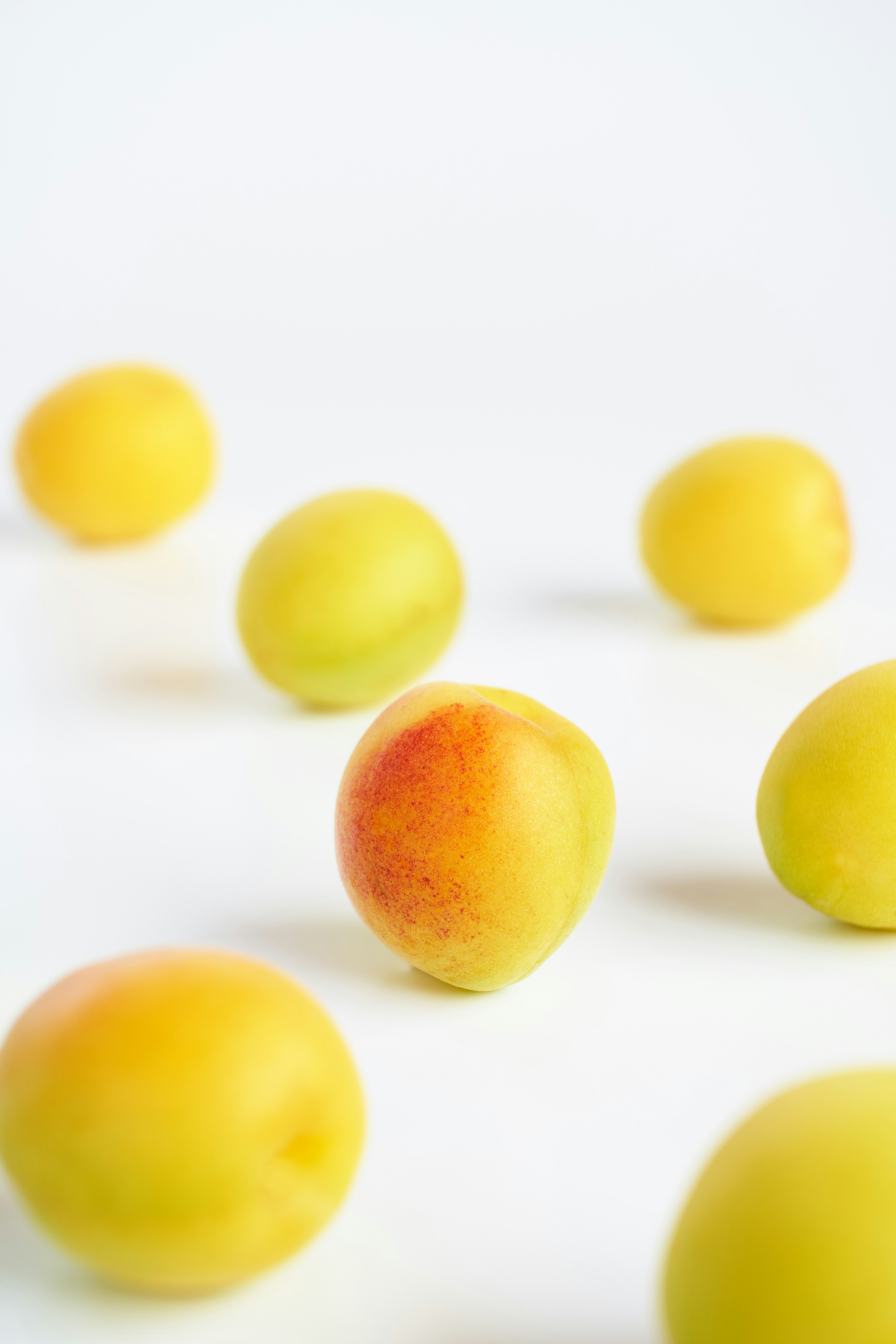 Un grupo de frutas amarillas esparcidas sobre un fondo blanco