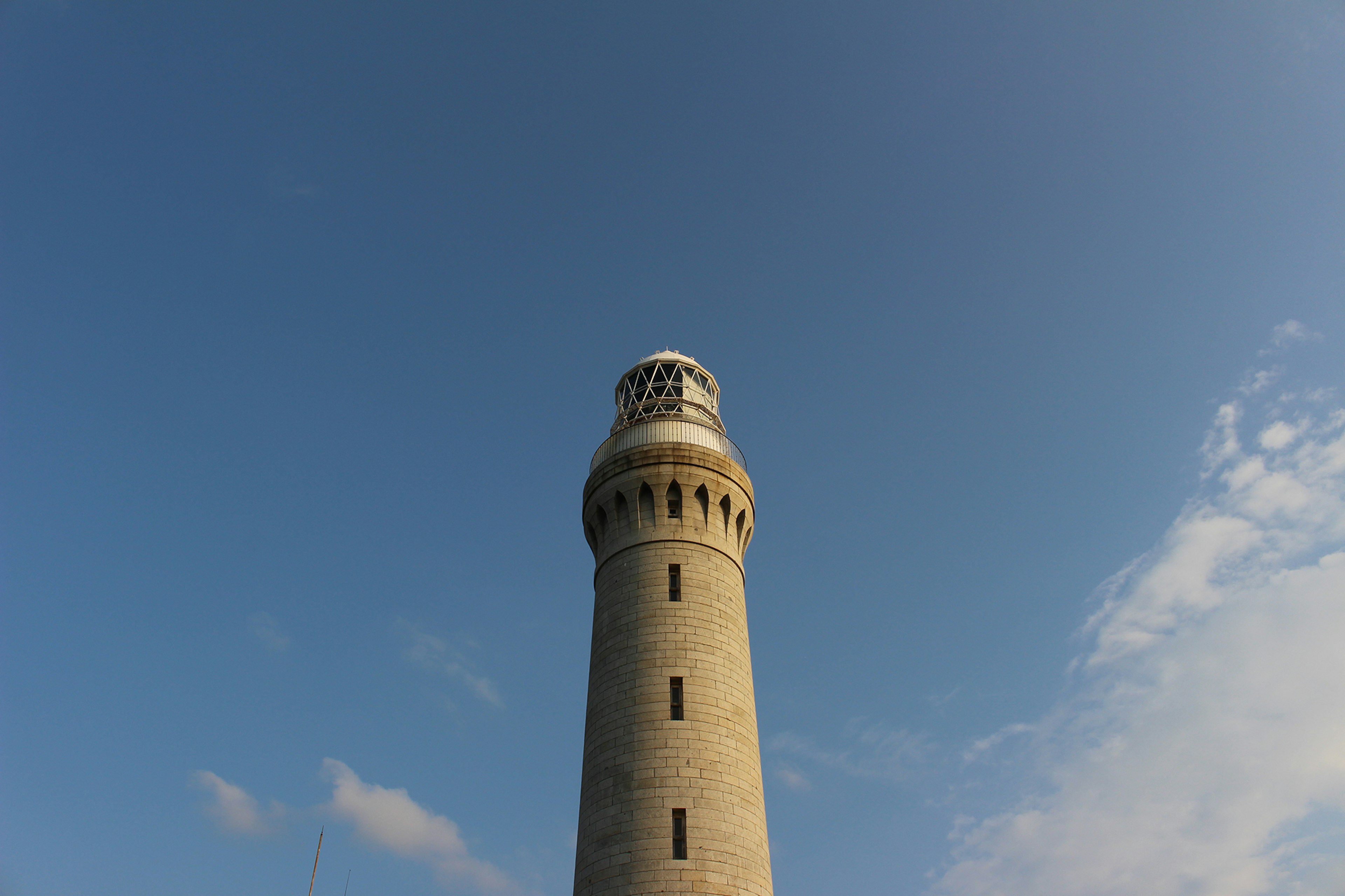 Hoher Leuchtturm steht unter einem blauen Himmel