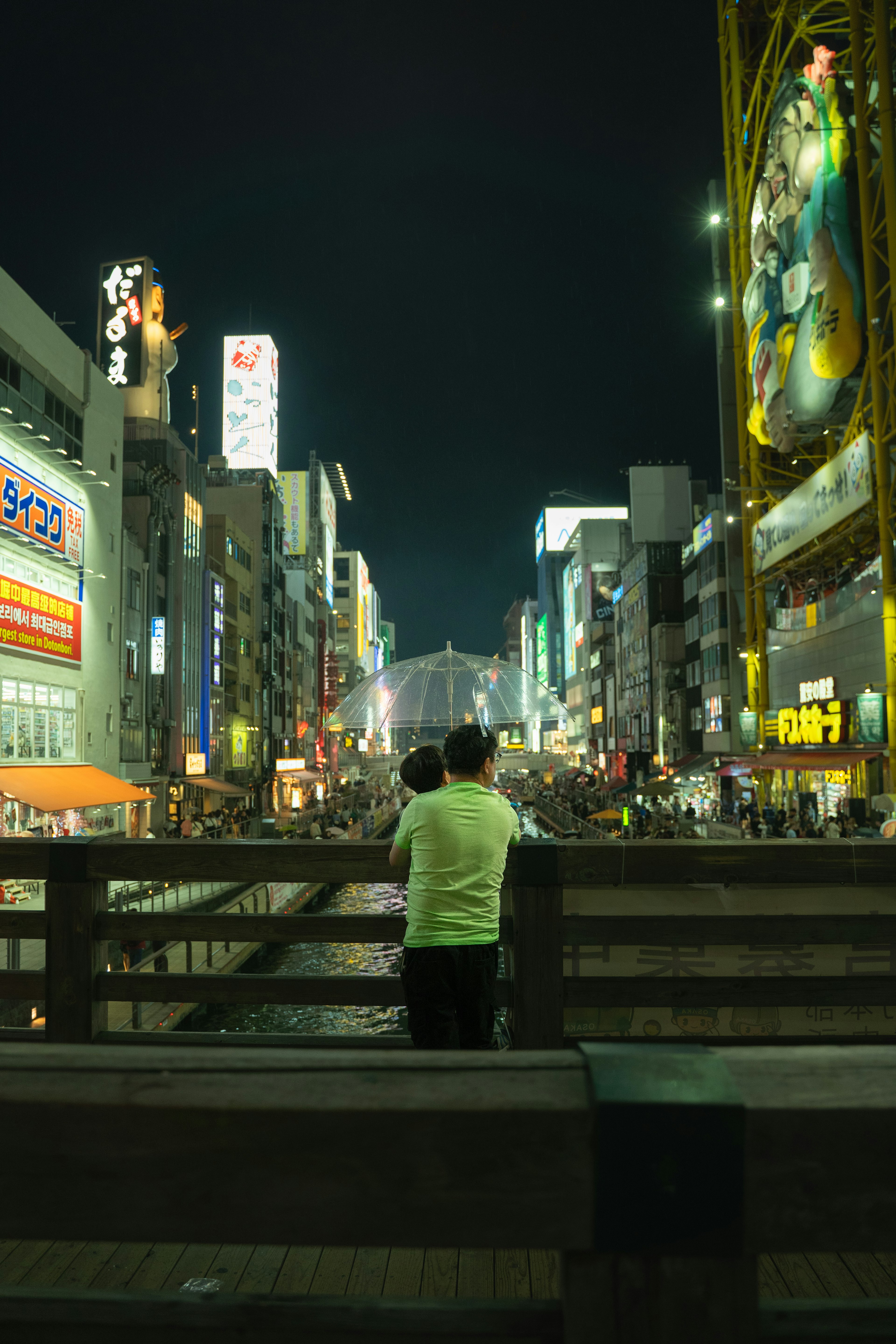 夜の都市景観で橋の上に立つ人が見える