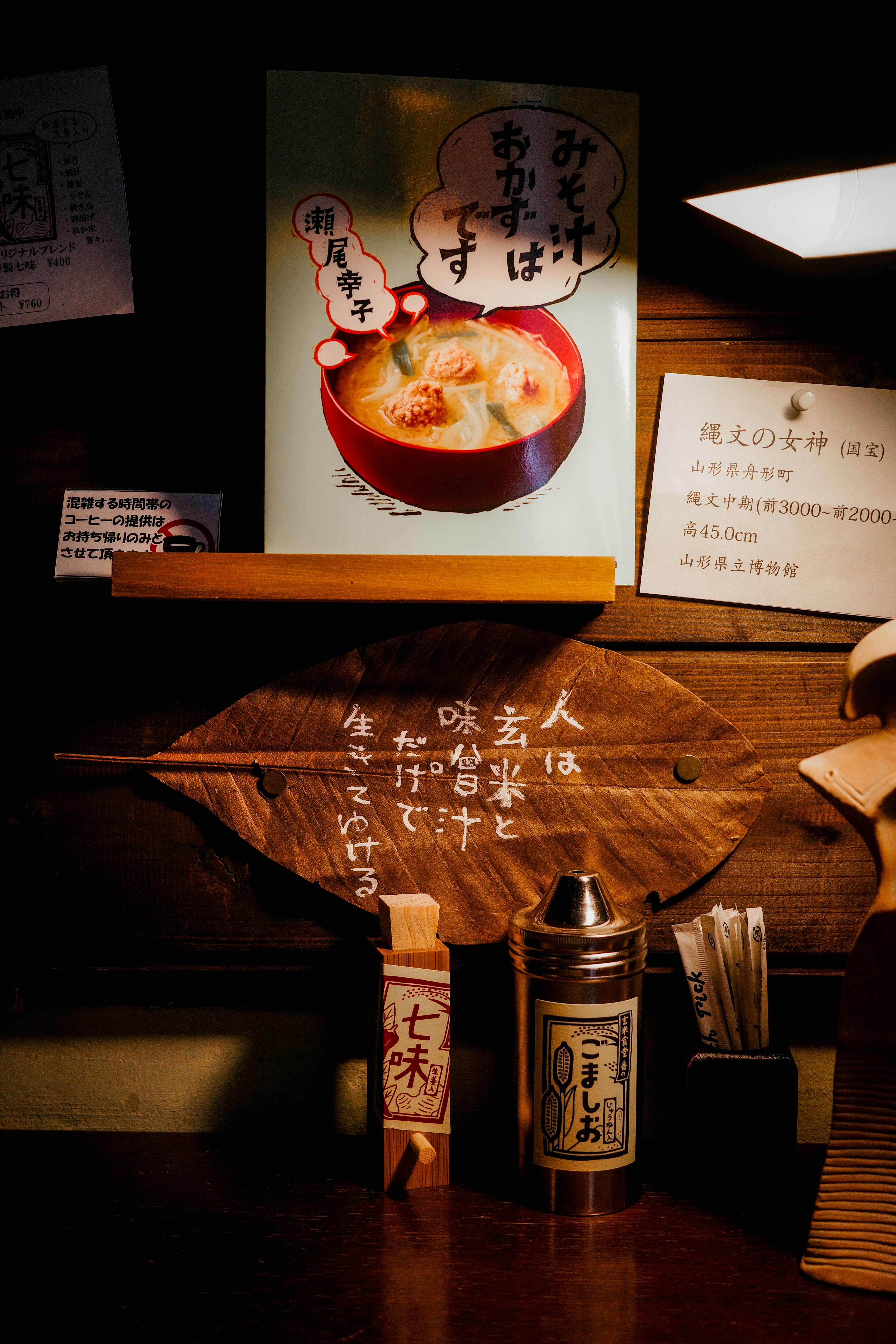 木製の看板と調味料が並ぶ和風の料理店のカウンター