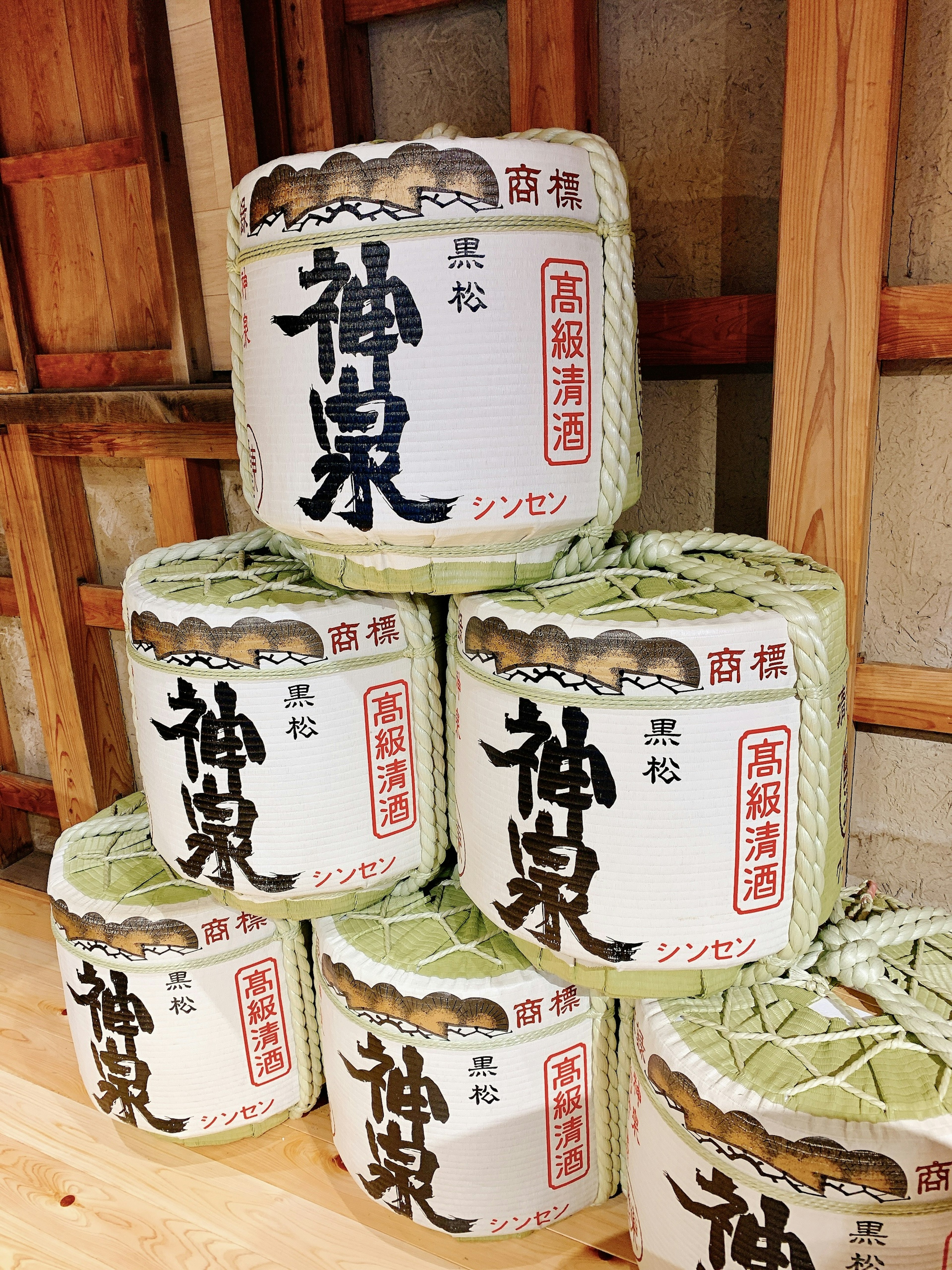 Barriles de sake apilados con etiquetas japonesas tradicionales