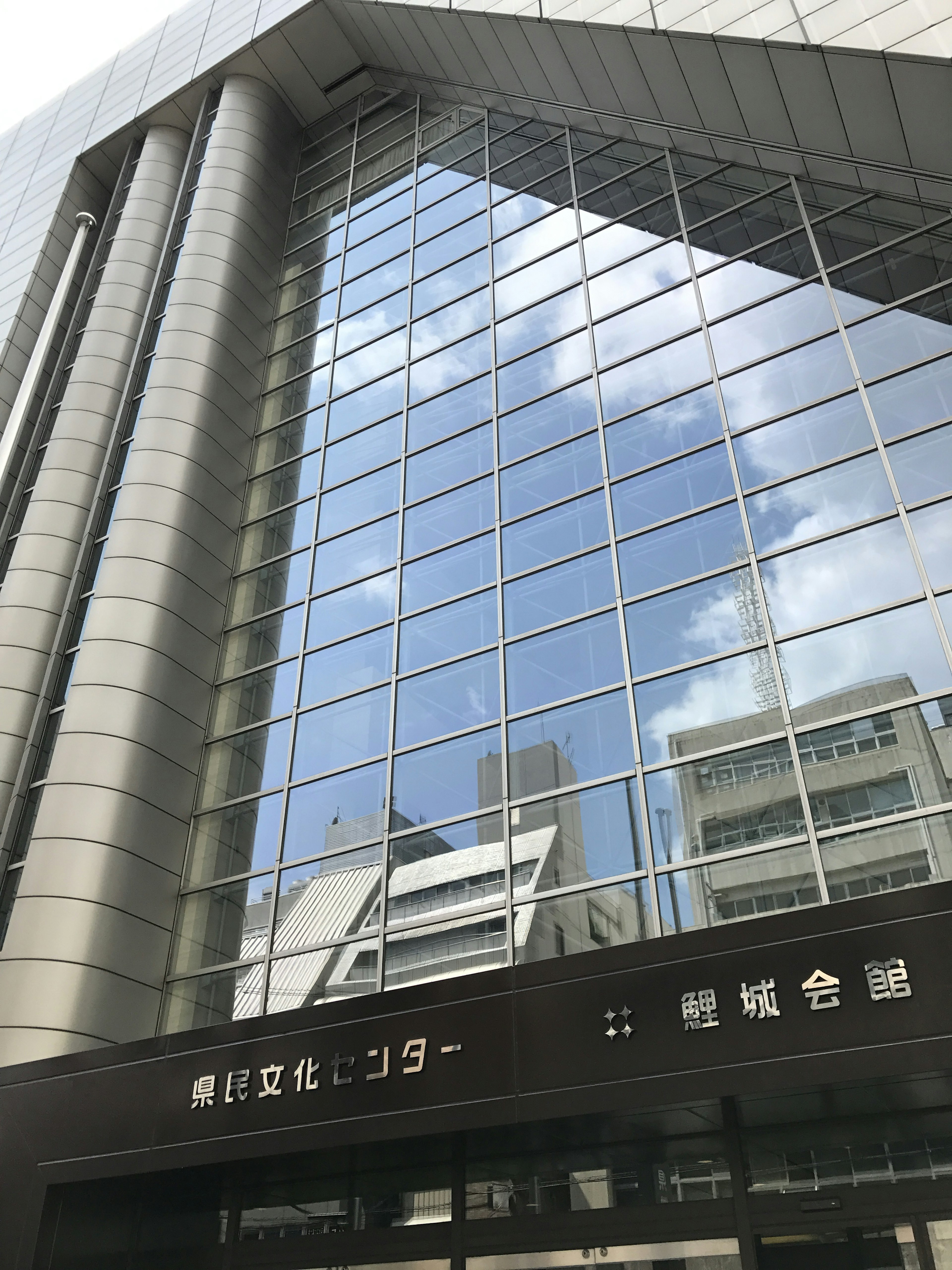 Modern glass building exterior reflecting blue sky