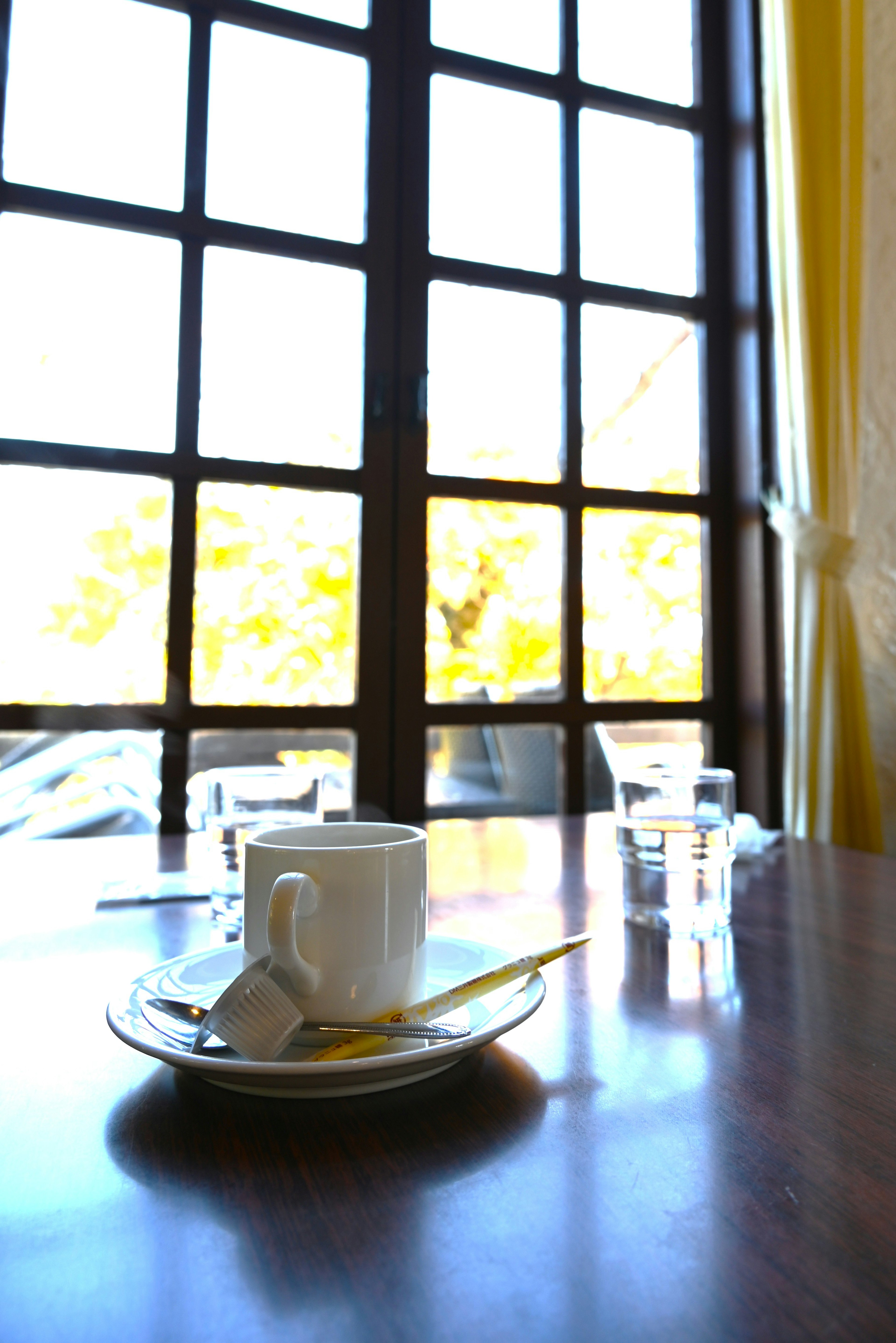 Coffee cup on a table with sunlight streaming through a window