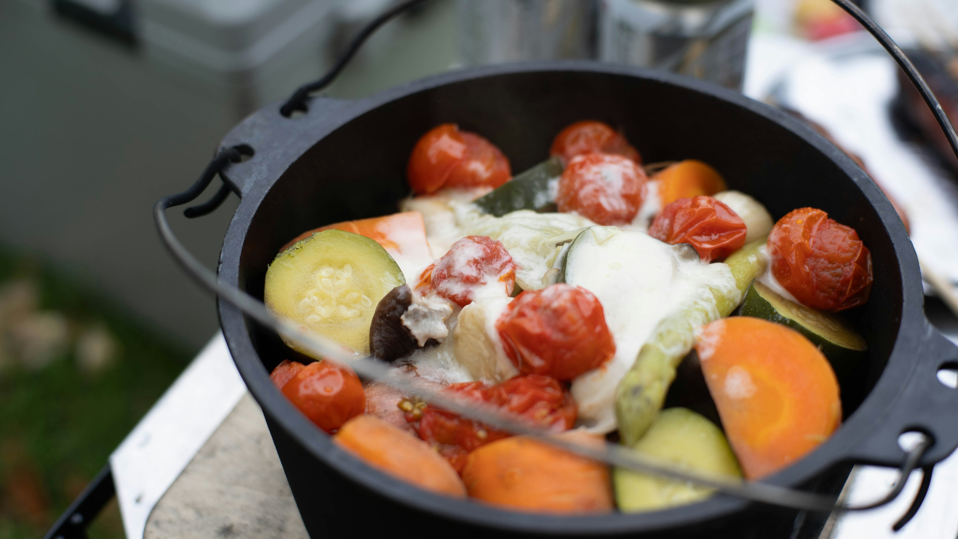 Colorful vegetables and tomatoes in a black pot