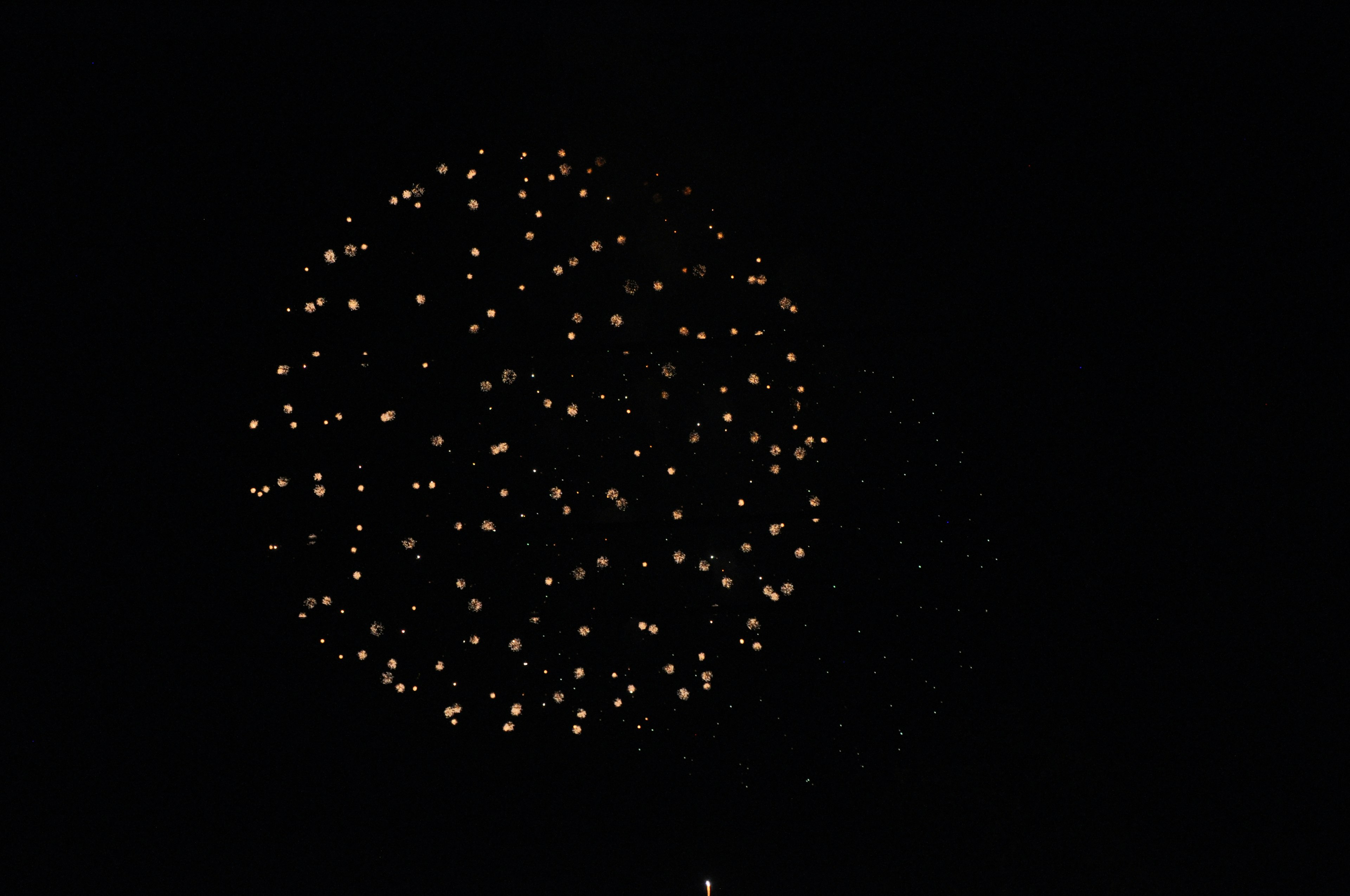 Fuochi d'artificio dorati che esplodono nel cielo notturno con uno sfondo scuro