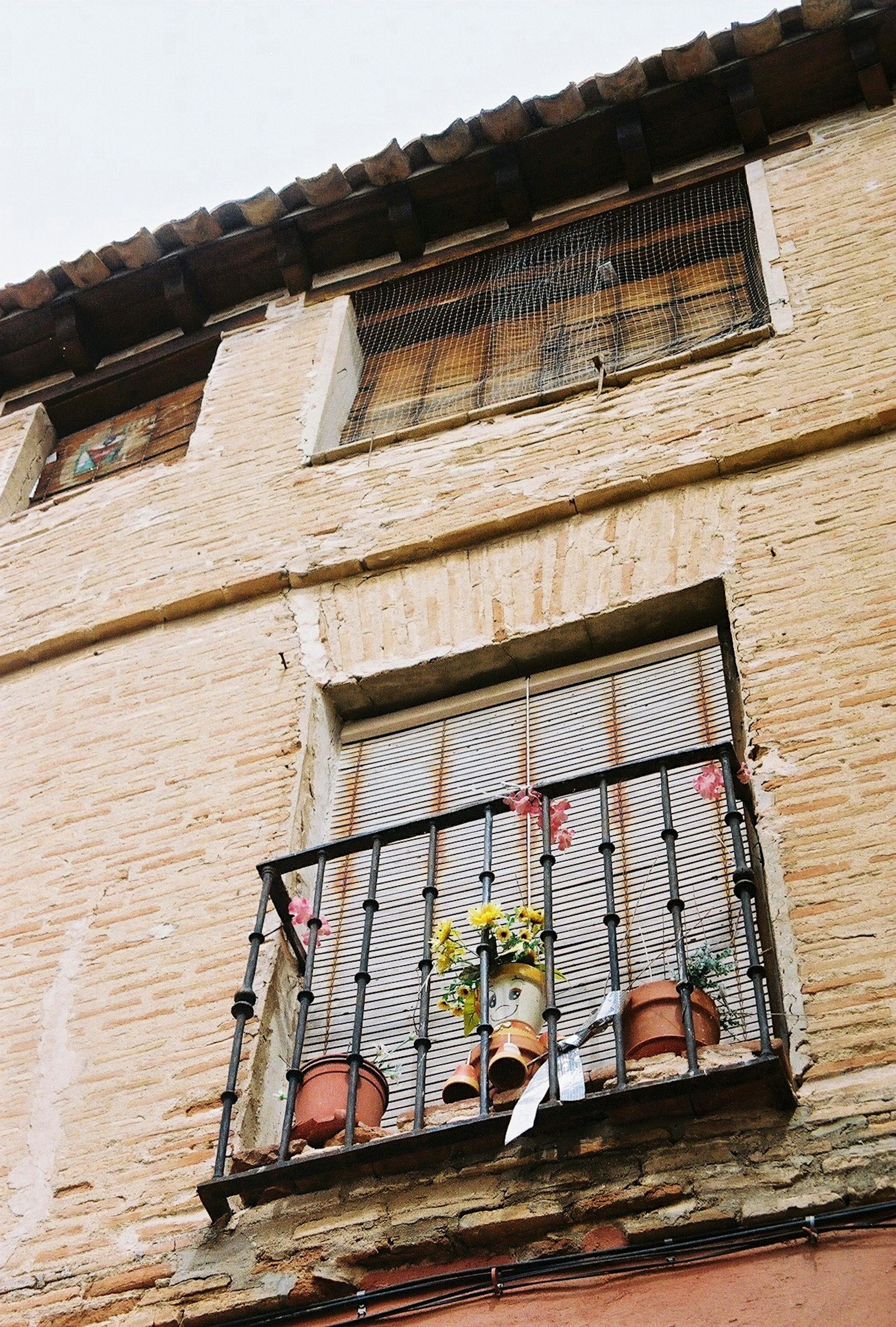 Balcon avec des pots de fleurs sur un vieux bâtiment