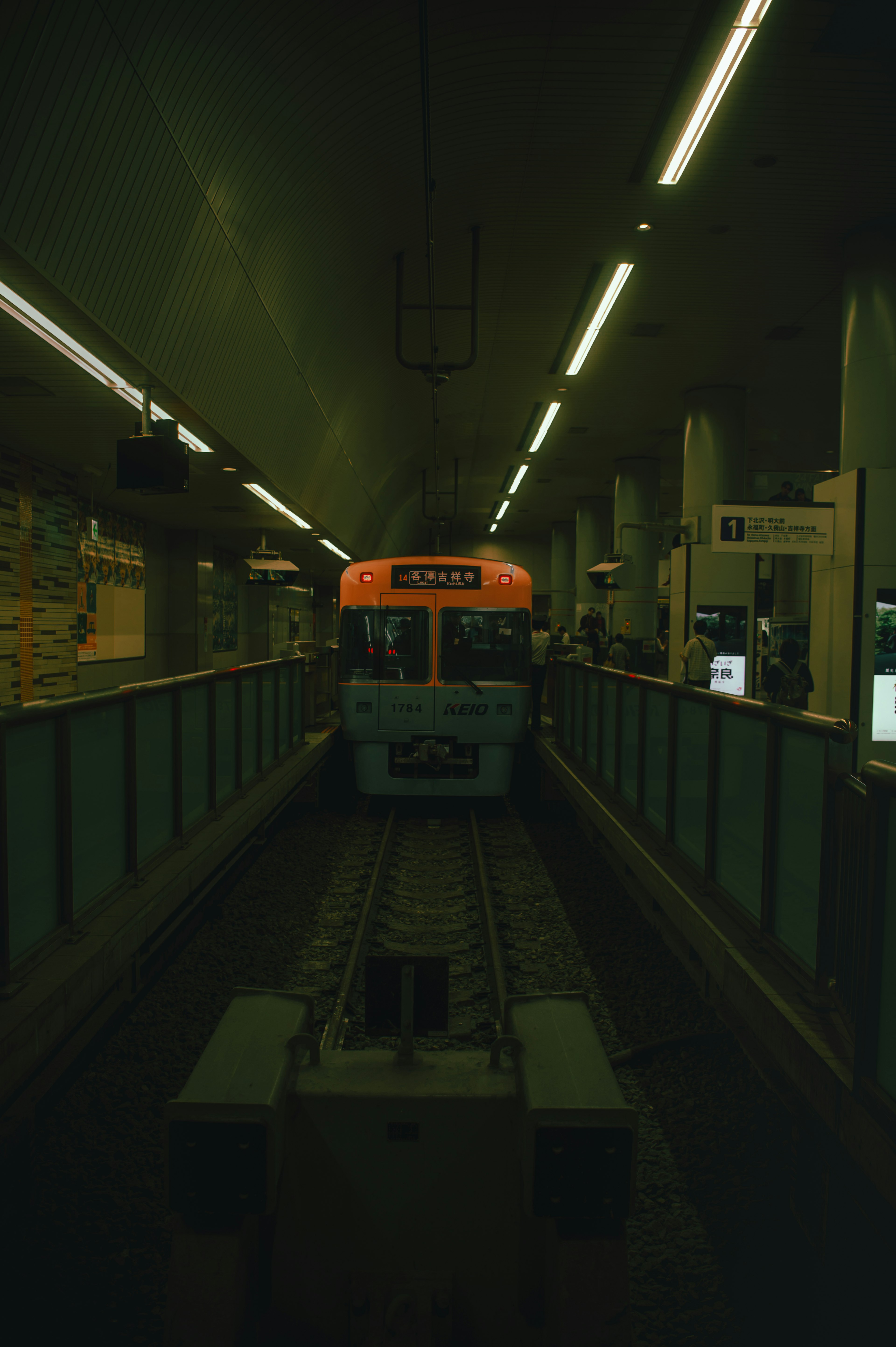 Orange train stopped in a dimly lit station