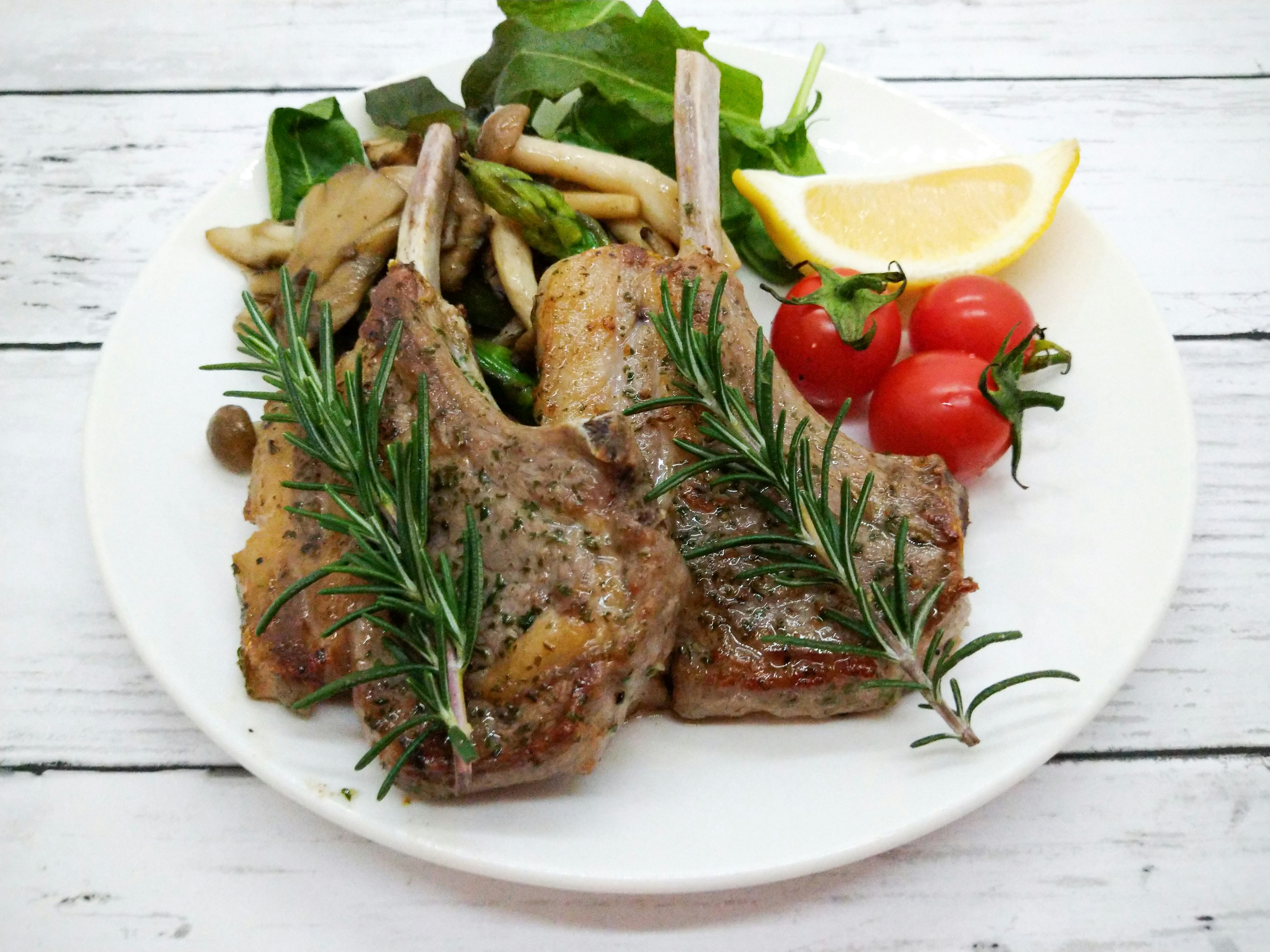 Délicieuses côtelettes d'agneau servies avec des légumes et des herbes