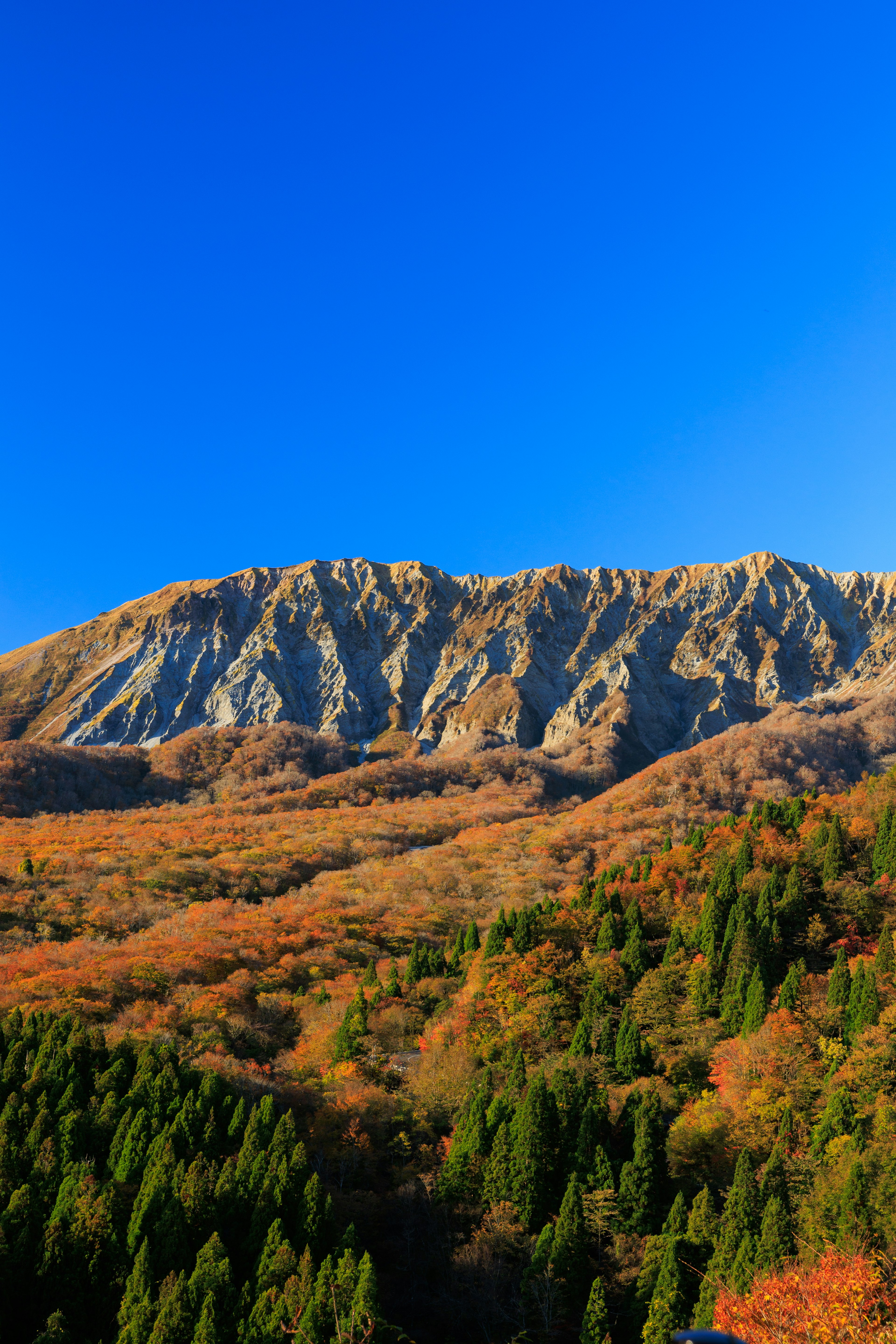 青空と紅葉の山々が広がる美しい風景