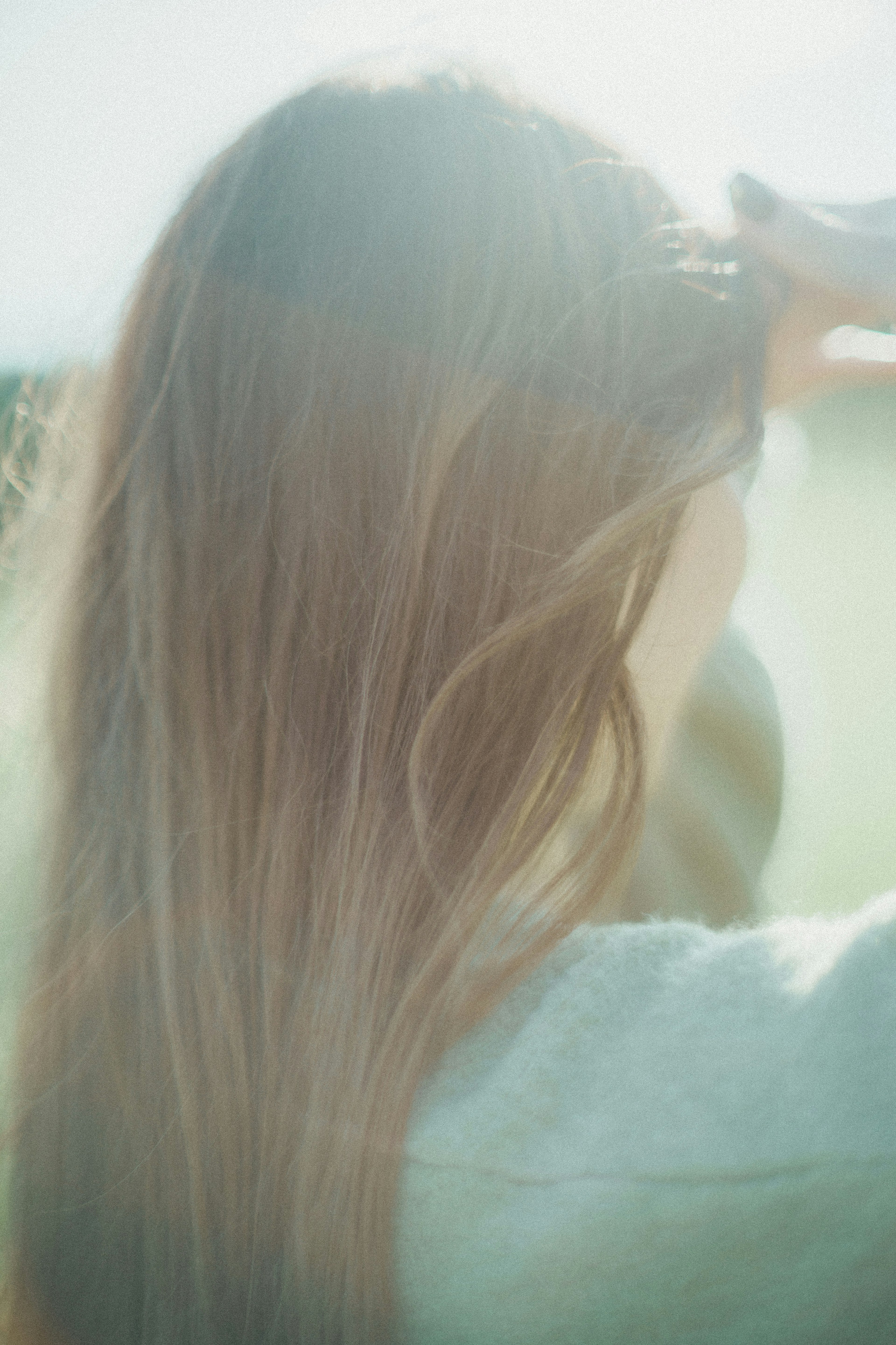 Vista posteriore di una donna con capelli lunghi in luce soffusa