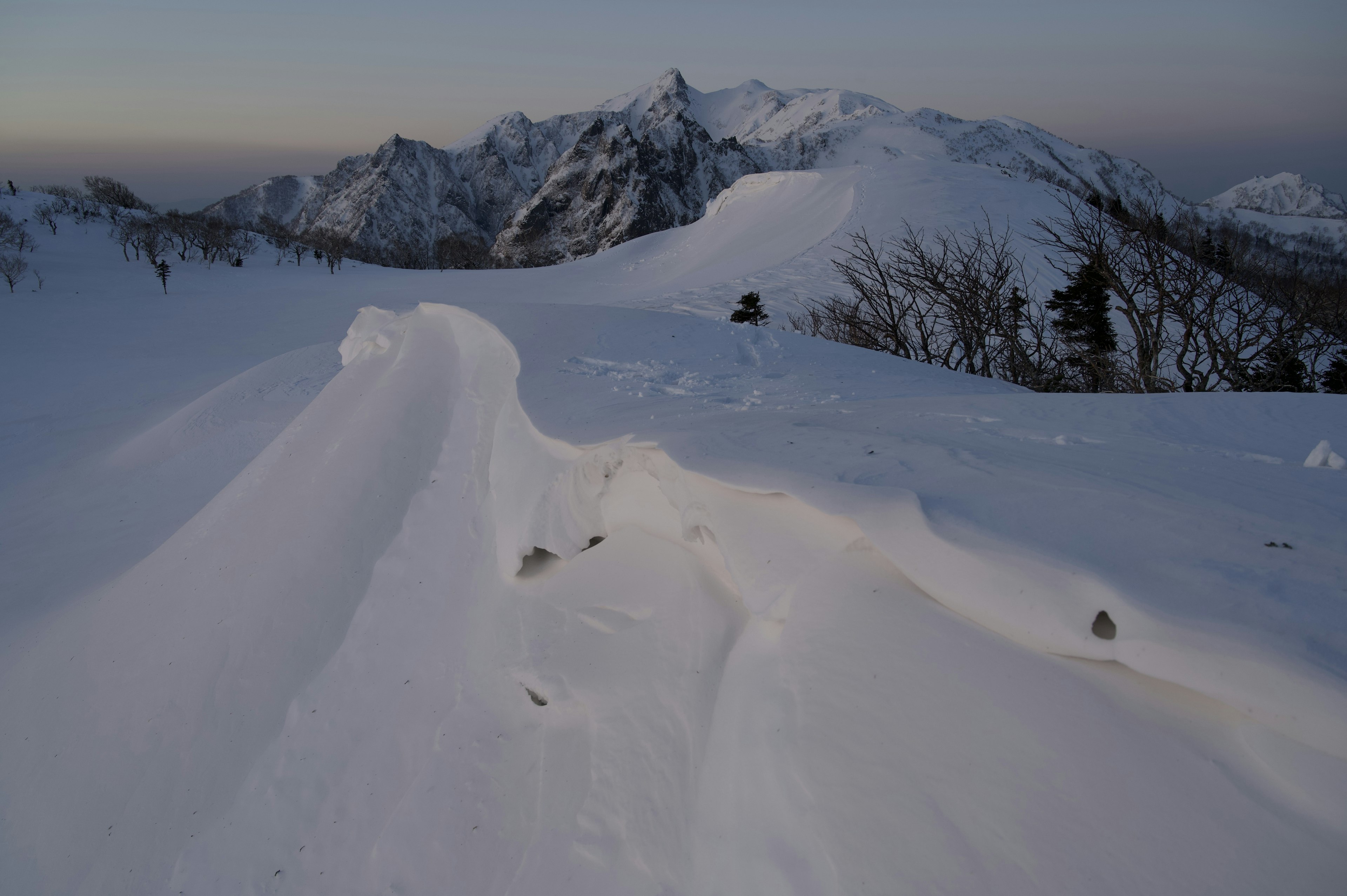 Schneebedeckte Berglandschaft mit glatten Schneebildungen