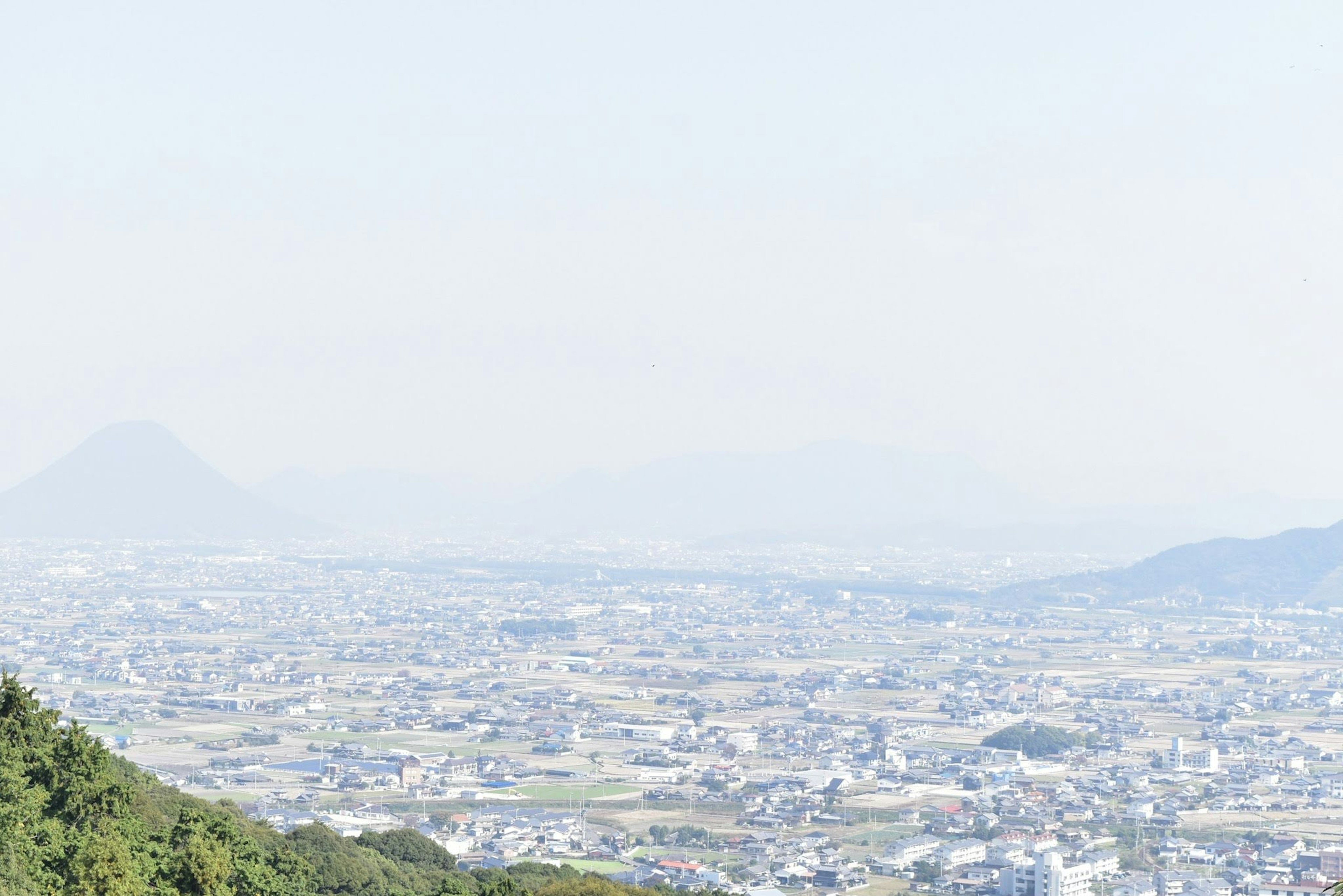 Paysage urbain vaste depuis une montagne avec des montagnes lointaines