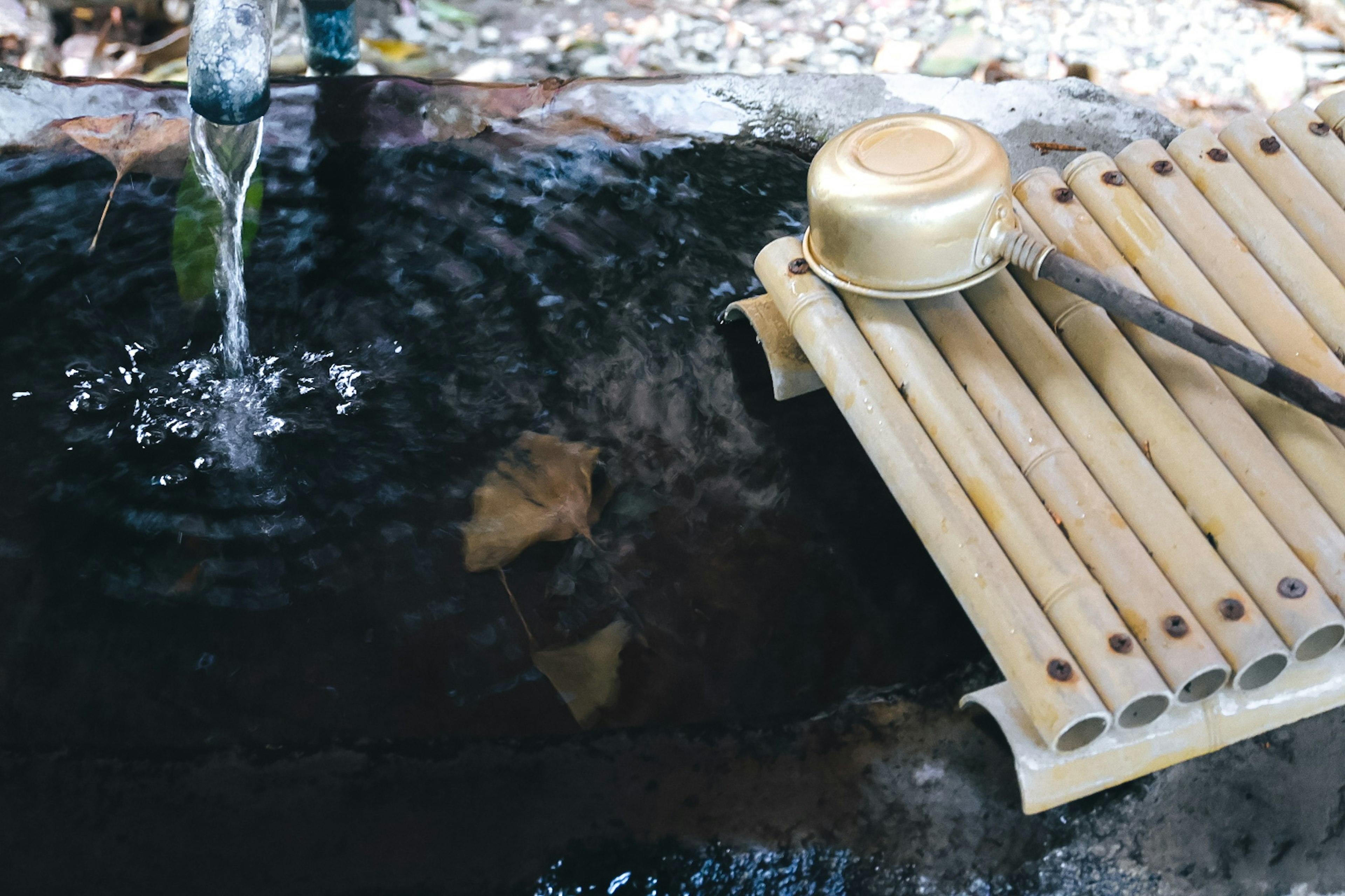 Eine ruhige Szene mit fließendem Wasser und einem Bambusbecken