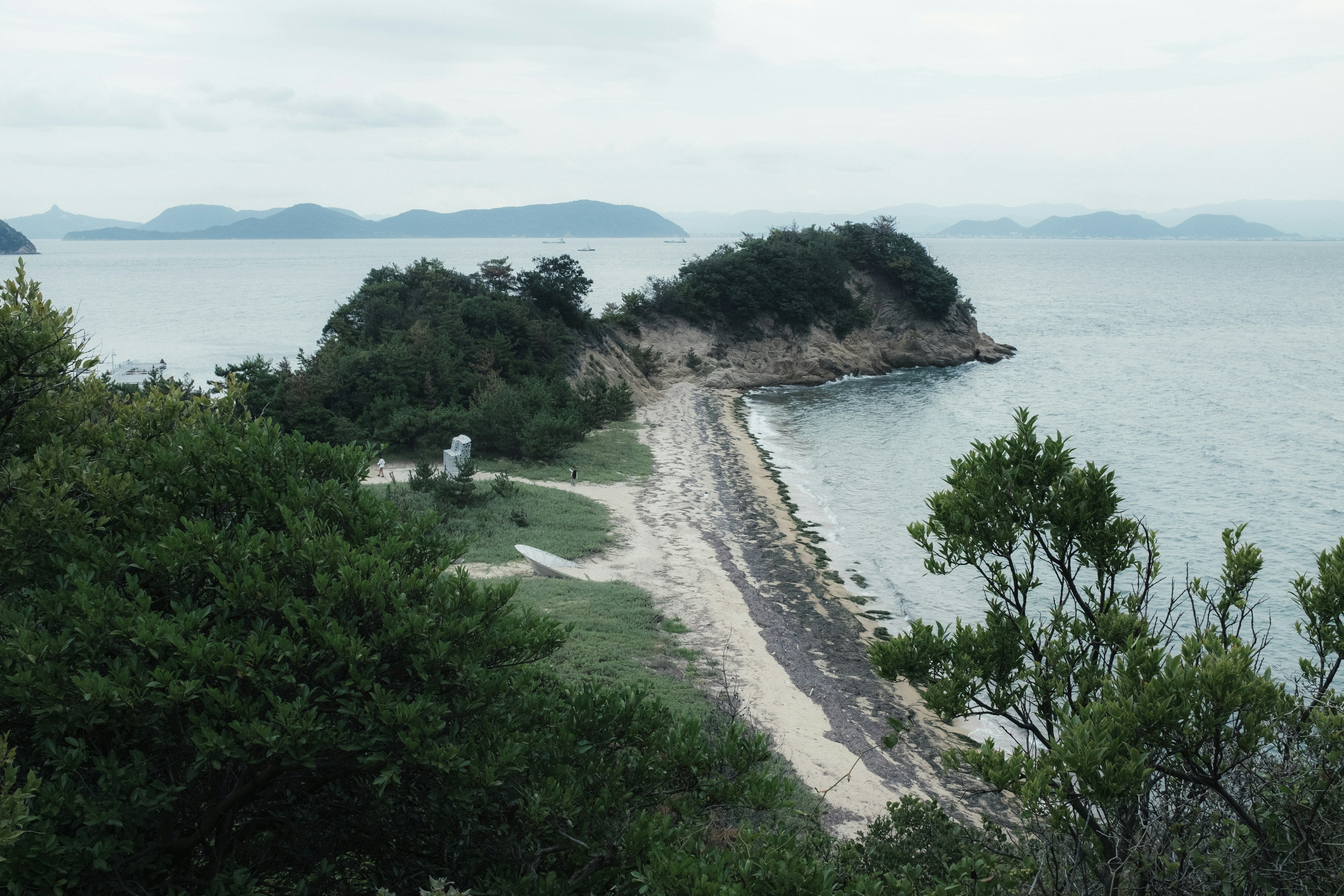 A scenic view of a small island surrounded by water with a sandy beach