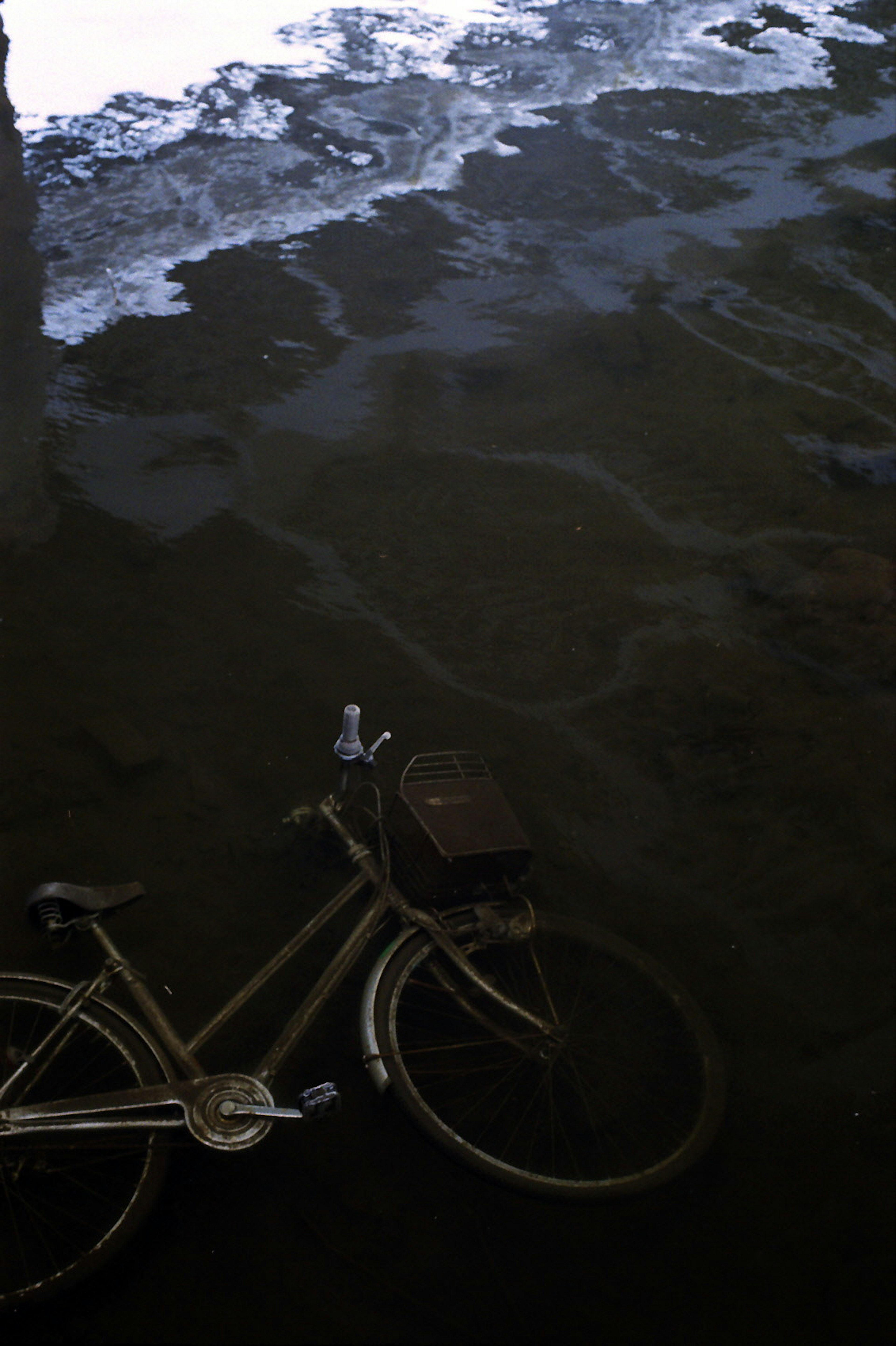 Silhouette d'un vélo reflété sur la surface de l'eau avec des ondulations