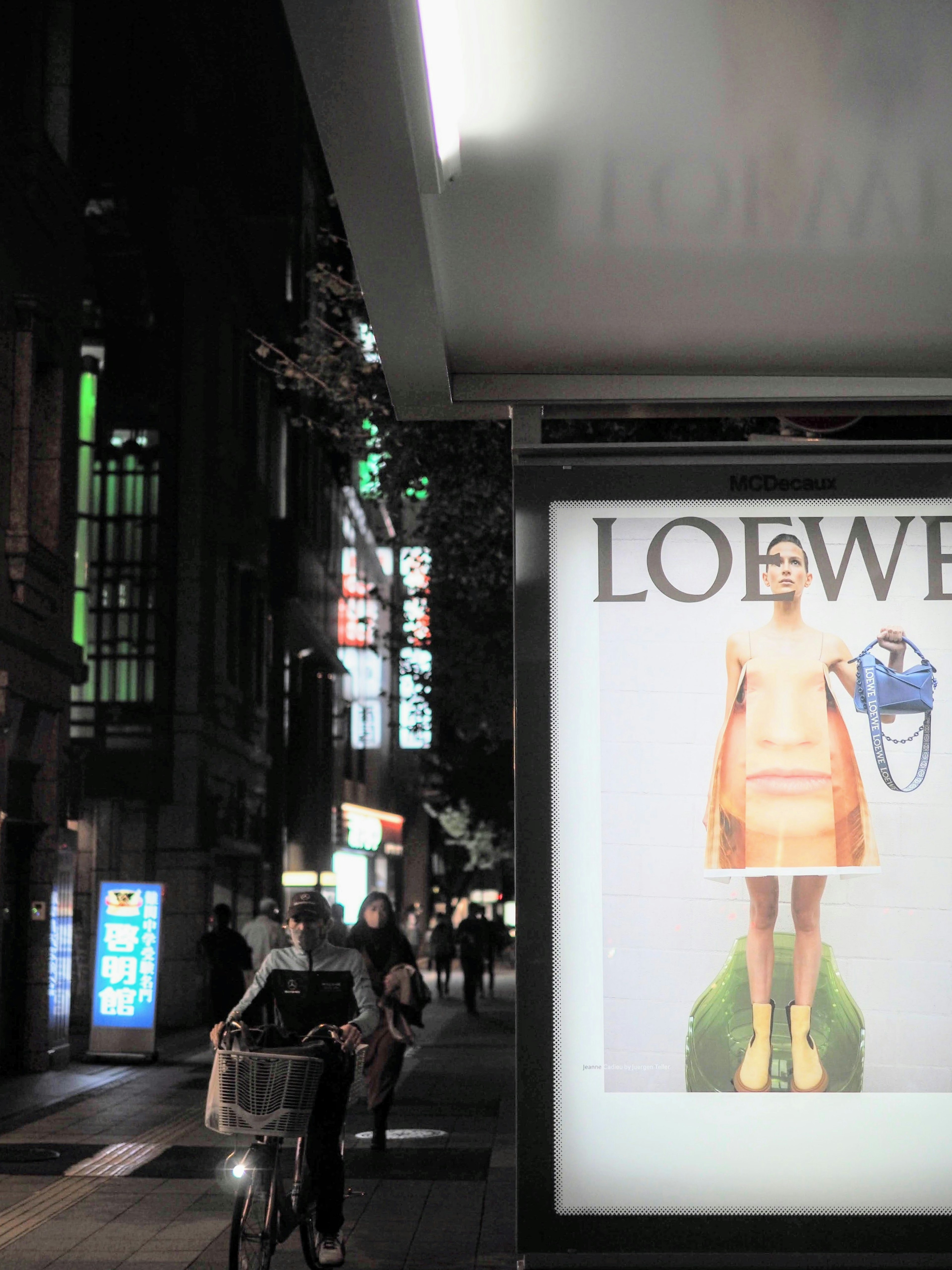 繁華街にあるLoeweの広告看板とファッションモデル