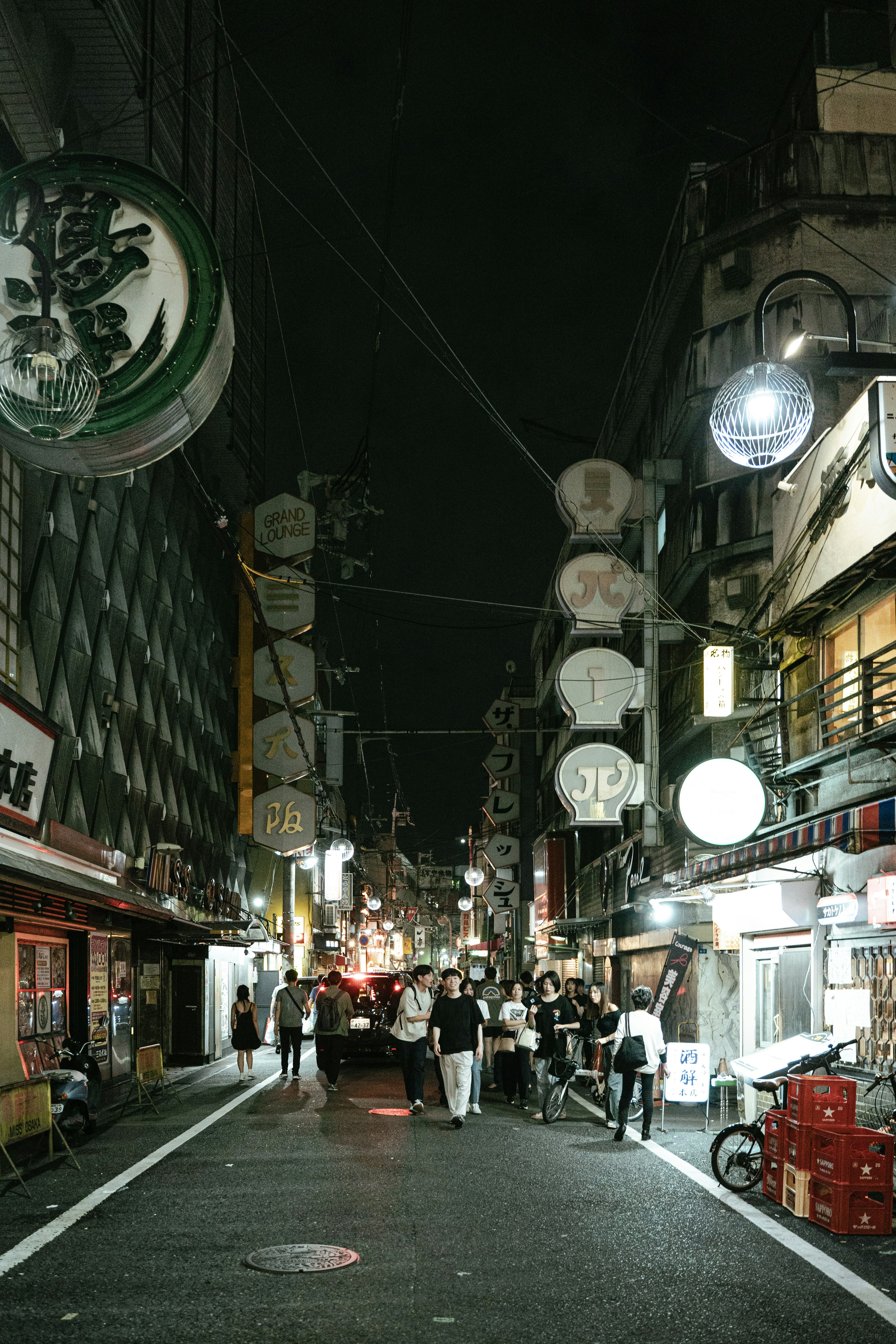 Street view at night featuring lanterns and storefronts