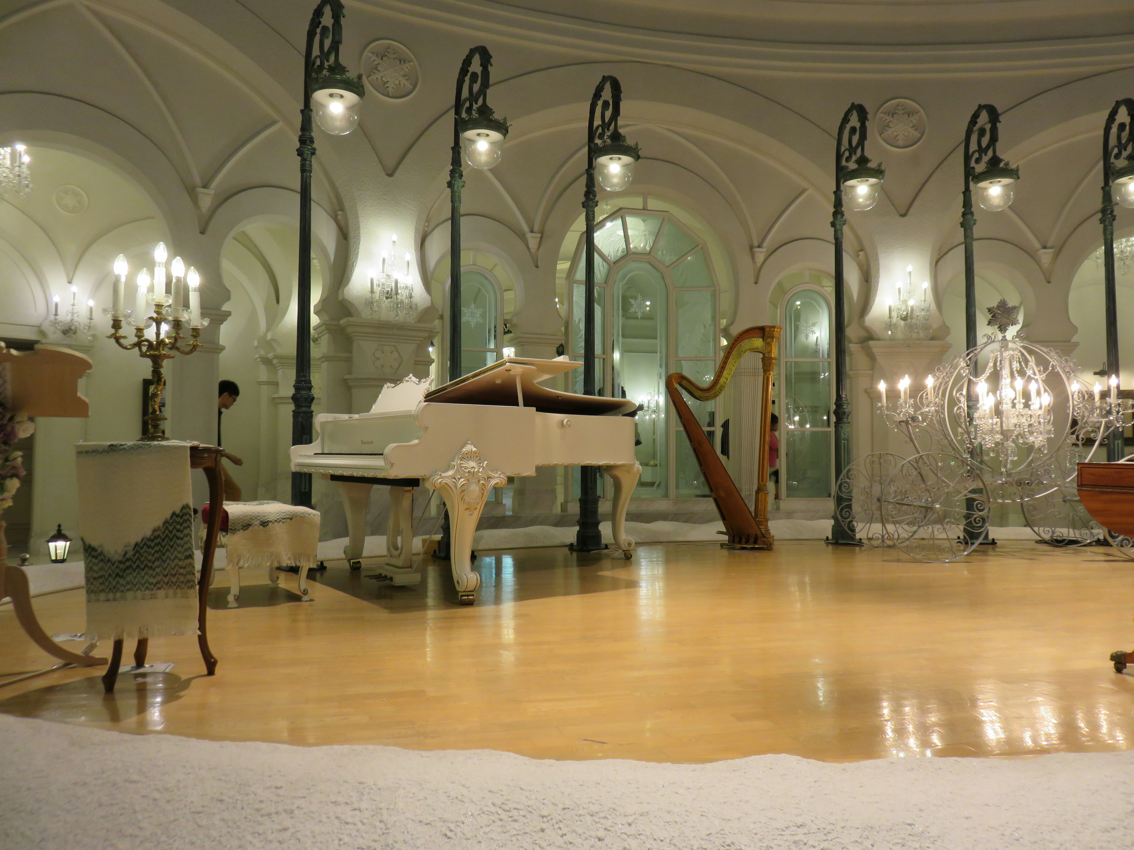 Elegant music room featuring a white piano and harp