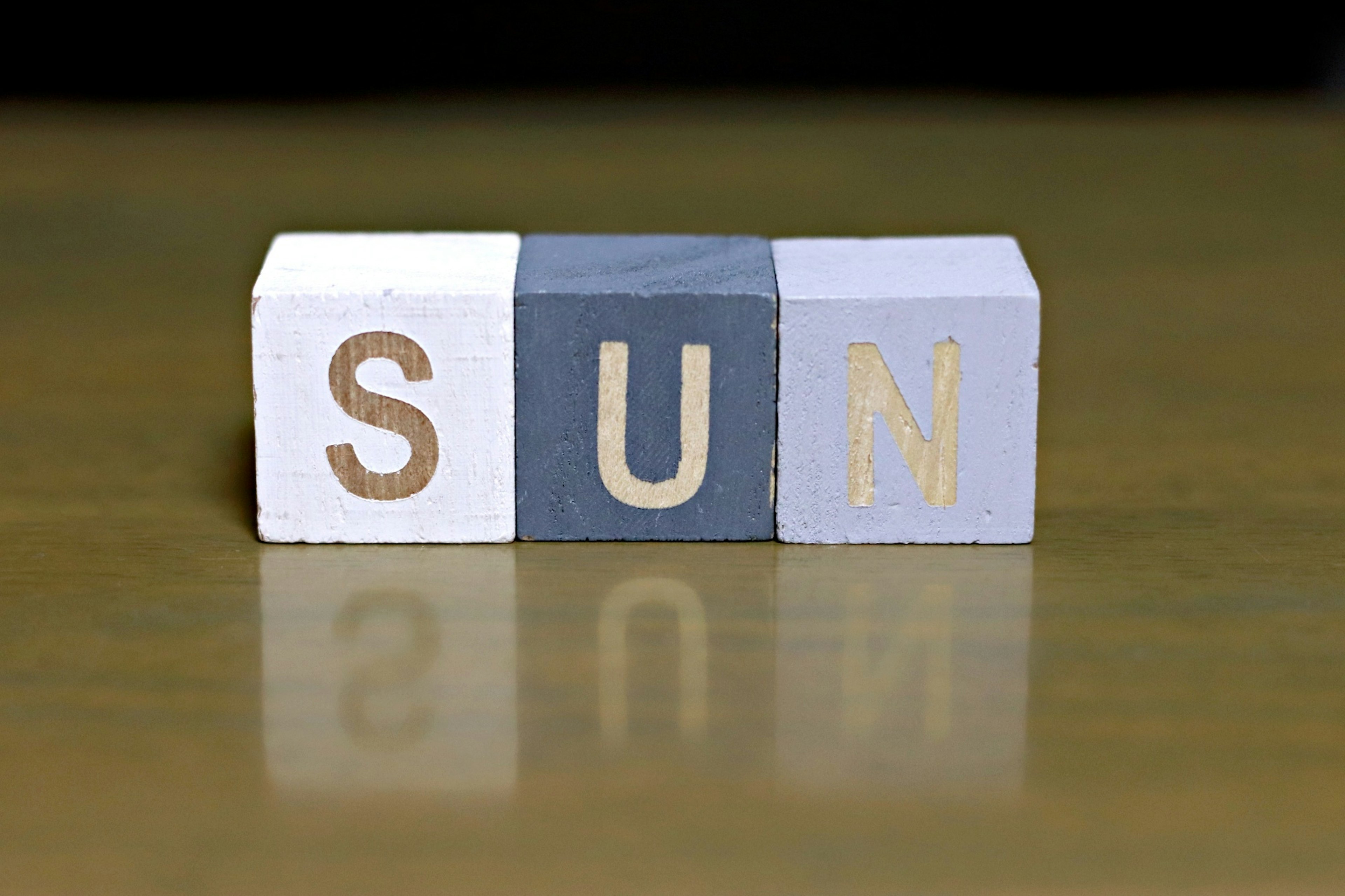 白とグレーのブロックに書かれた「SUN」の文字