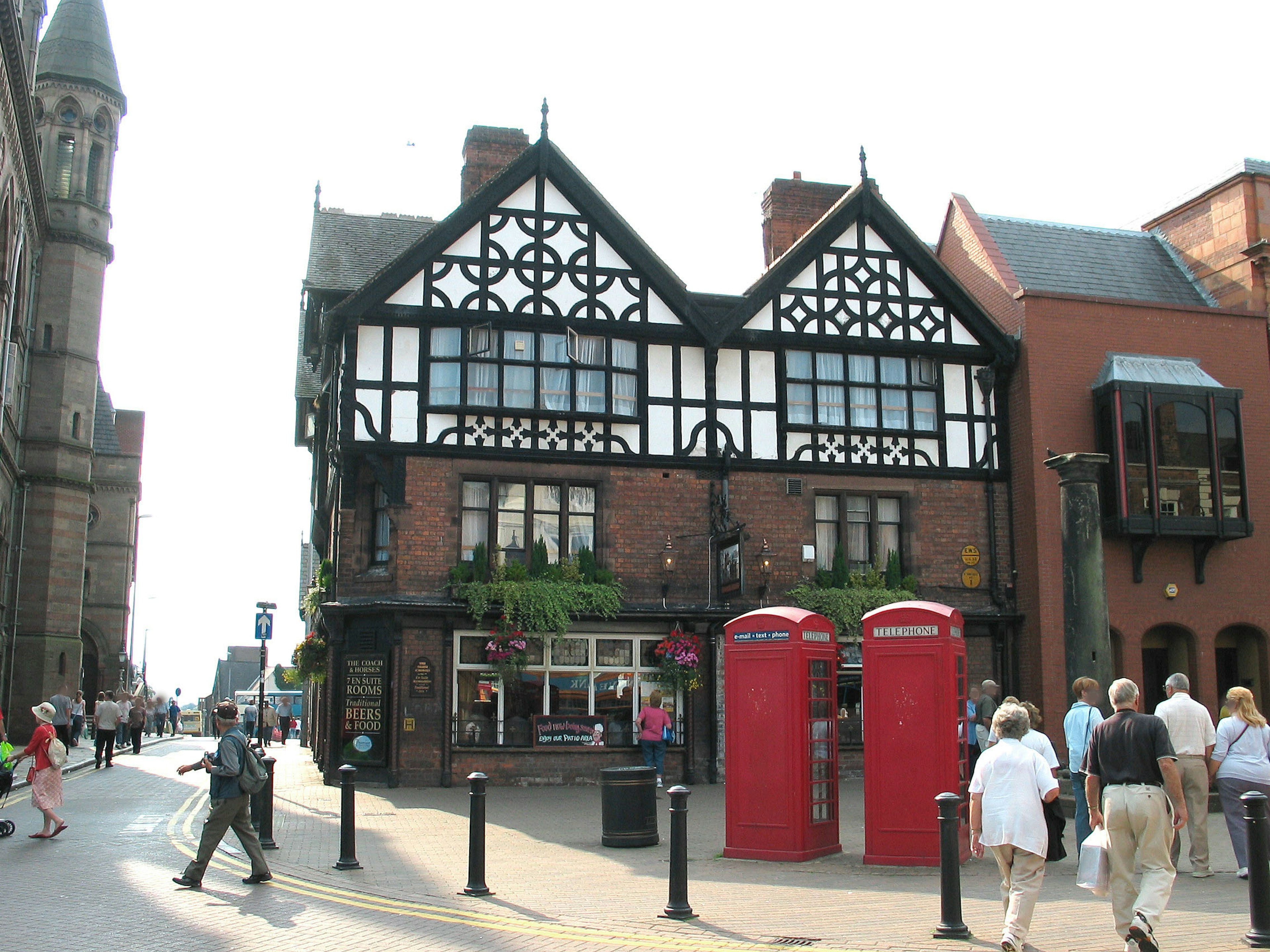 Street view featuring red telephone boxes and traditional English architecture