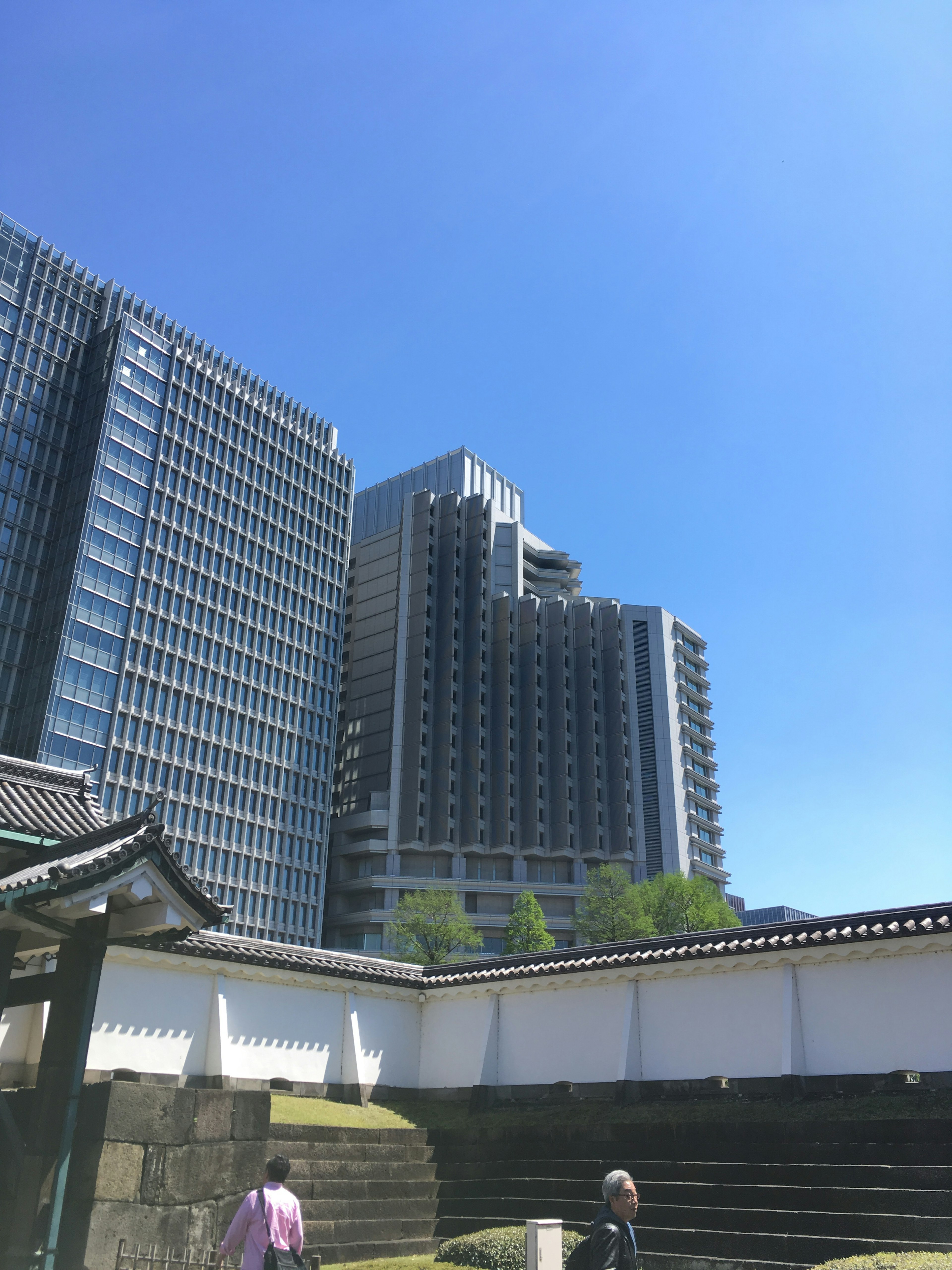 Eine Aussicht auf Wolkenkratzer vor blauem Himmel mit traditioneller japanischer Architektur im Vordergrund