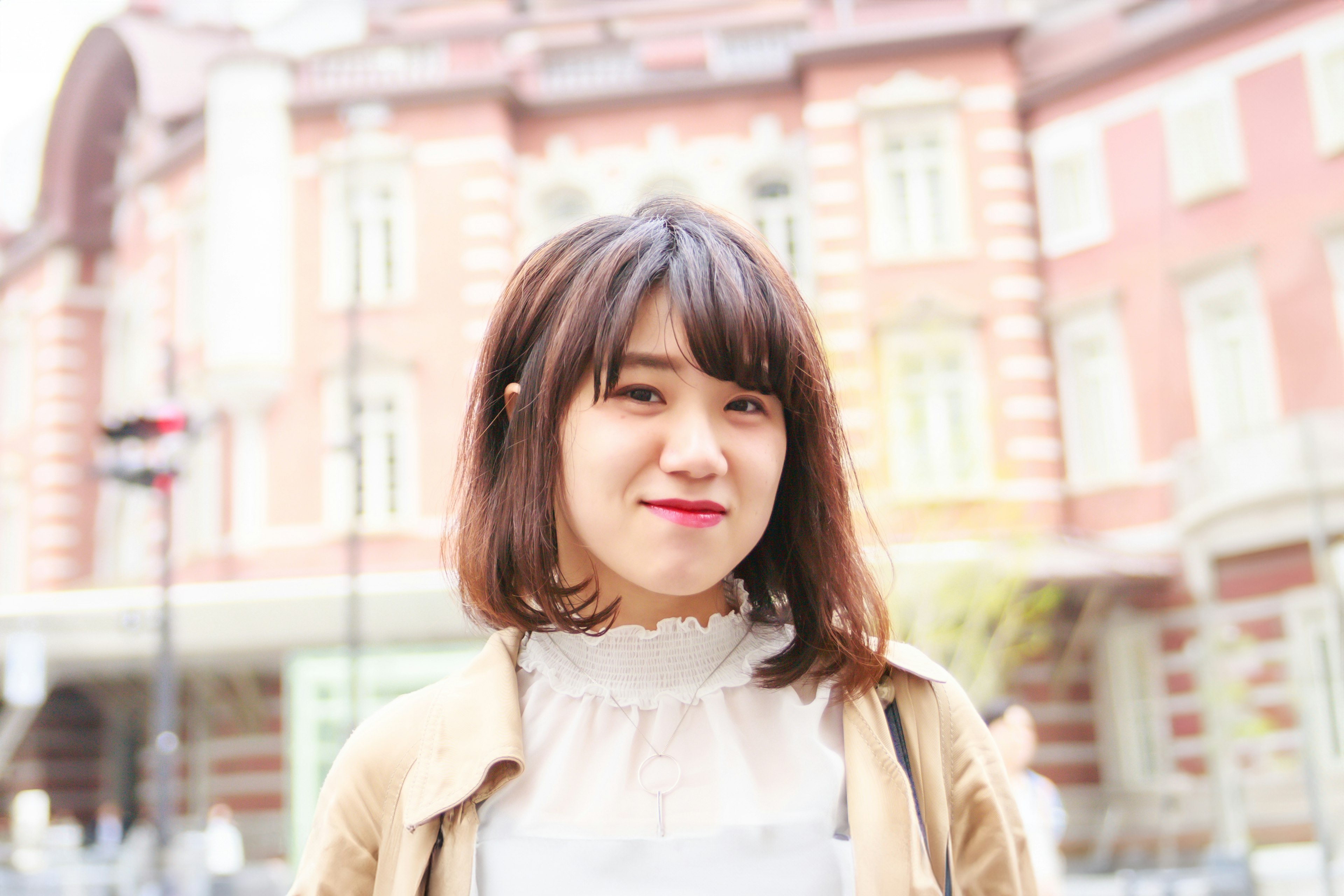 Une femme souriant devant la gare de Tokyo