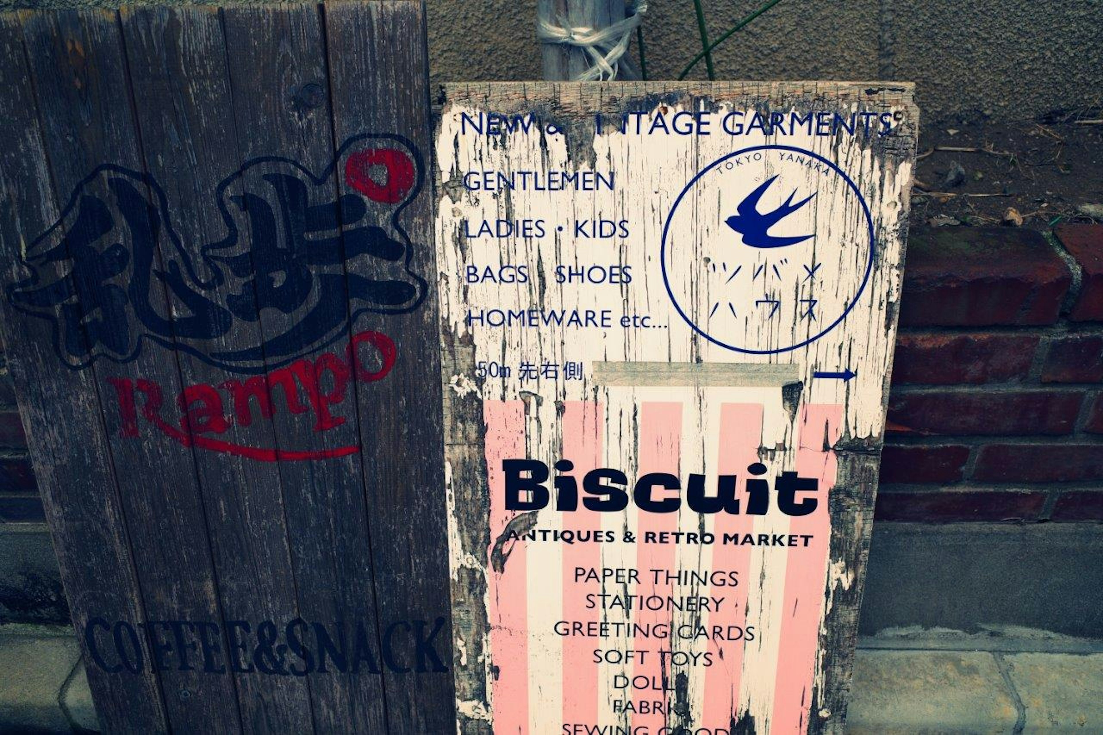 มุมถนนที่มีป้ายโบราณแสดง Biscuit และชื่อร้านกาแฟ