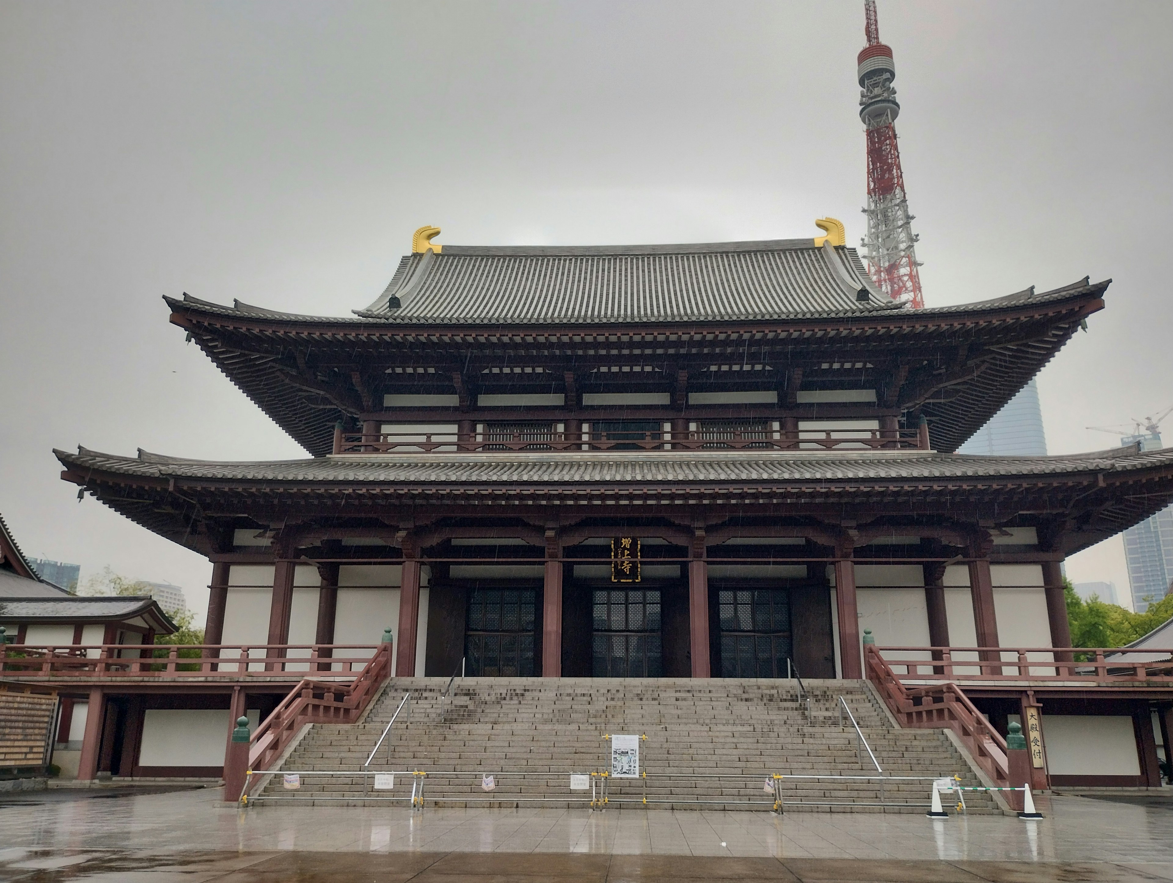 Vista frontale di un tempio giapponese tradizionale con la Torre di Tokyo sullo sfondo