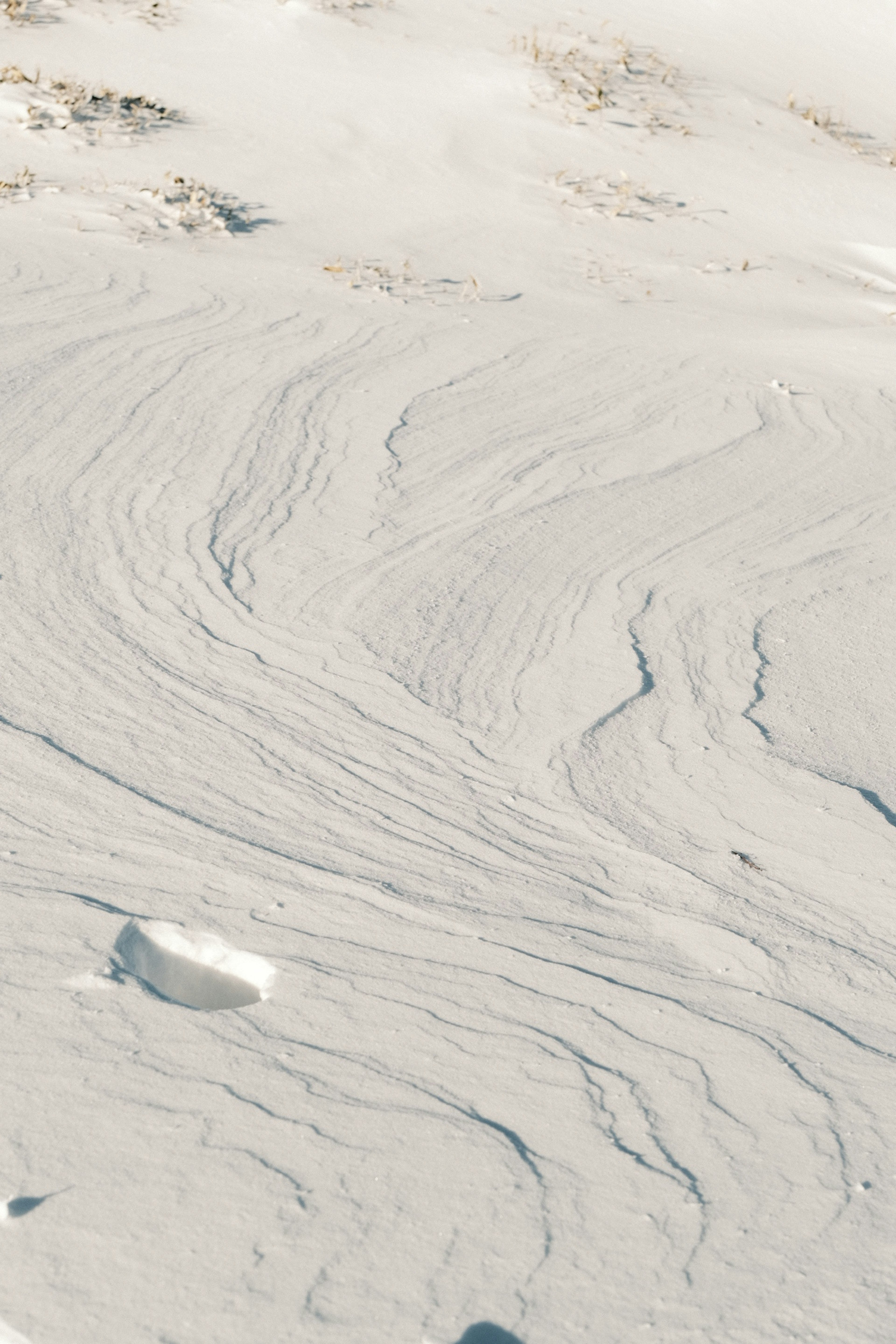 Motifs lisses sur une surface enneigée avec des morceaux de glace