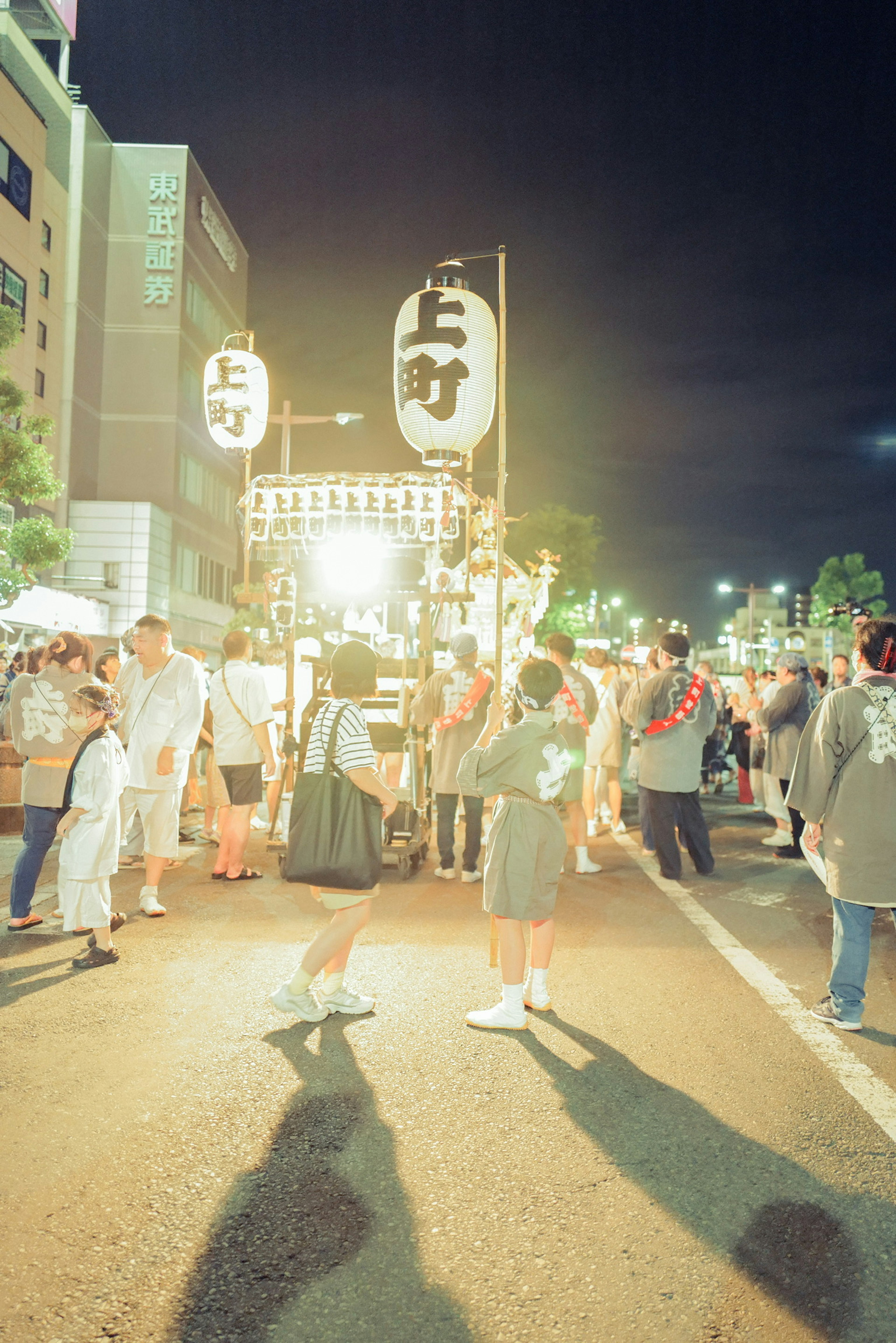 夜の祭りの賑わいを感じる人々の群れと明るい提灯