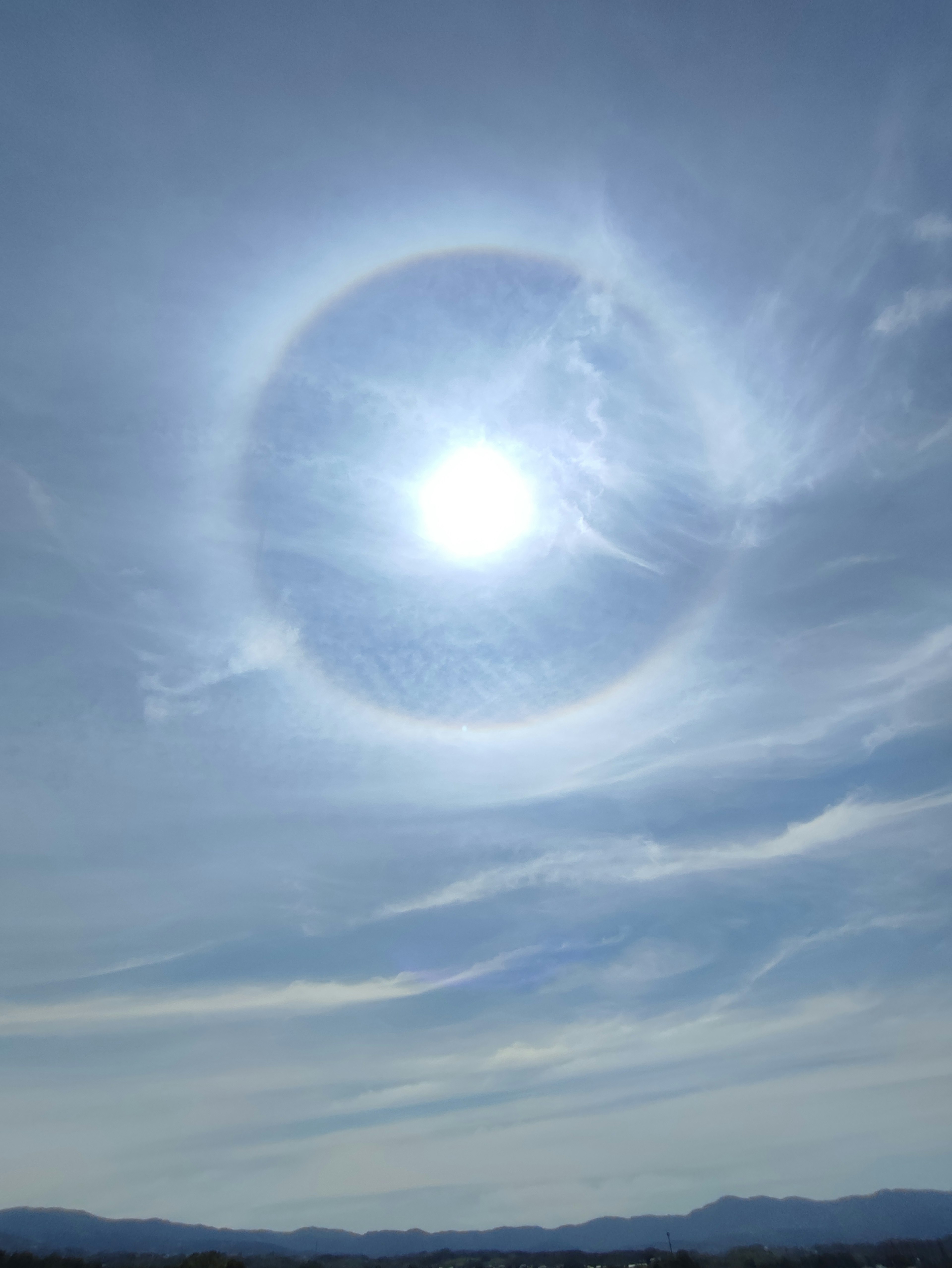 Un sole luminoso circondato da un alone in un cielo azzurro