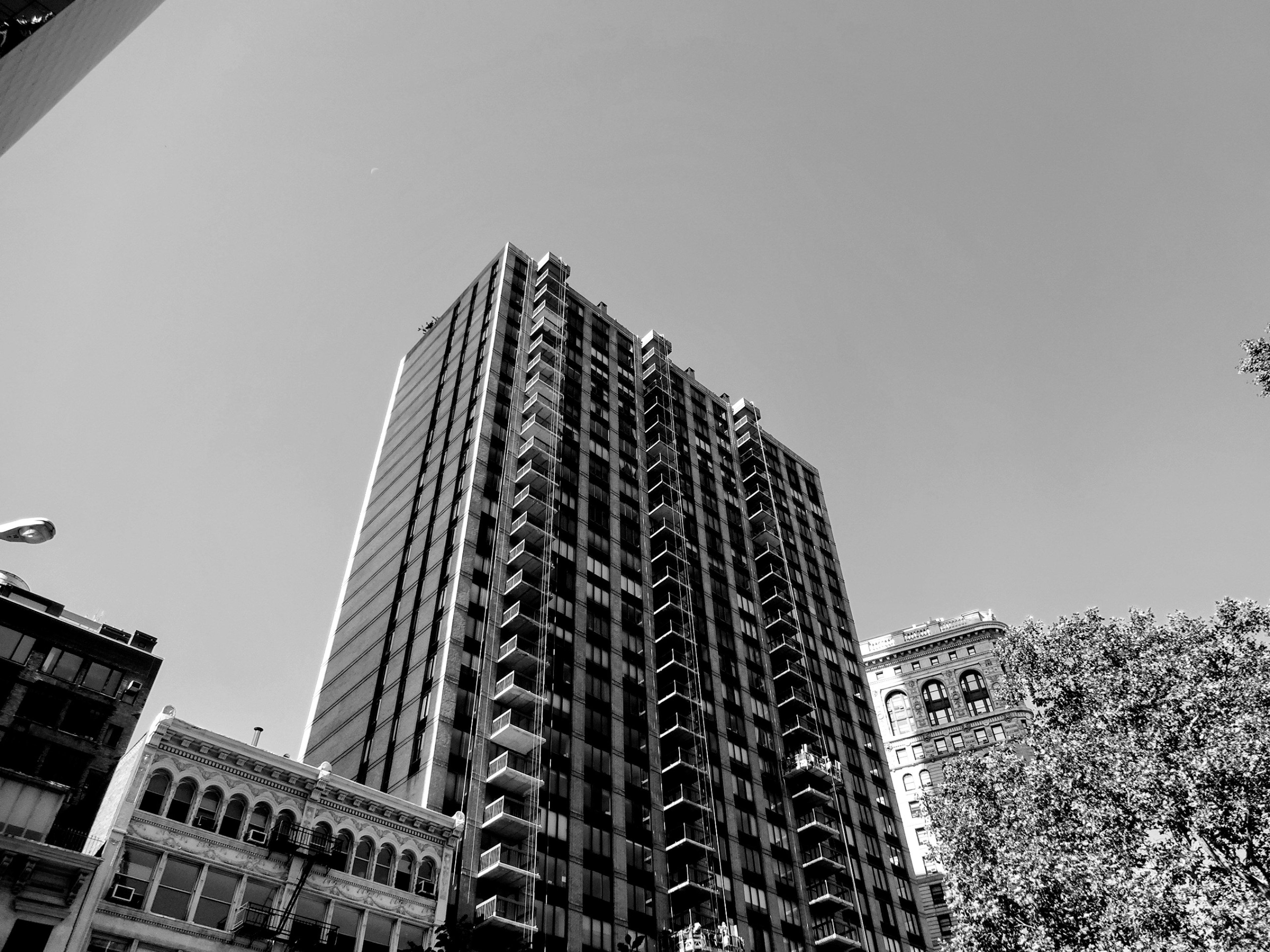 Low-angle view of a tall building contrasting with surrounding architecture