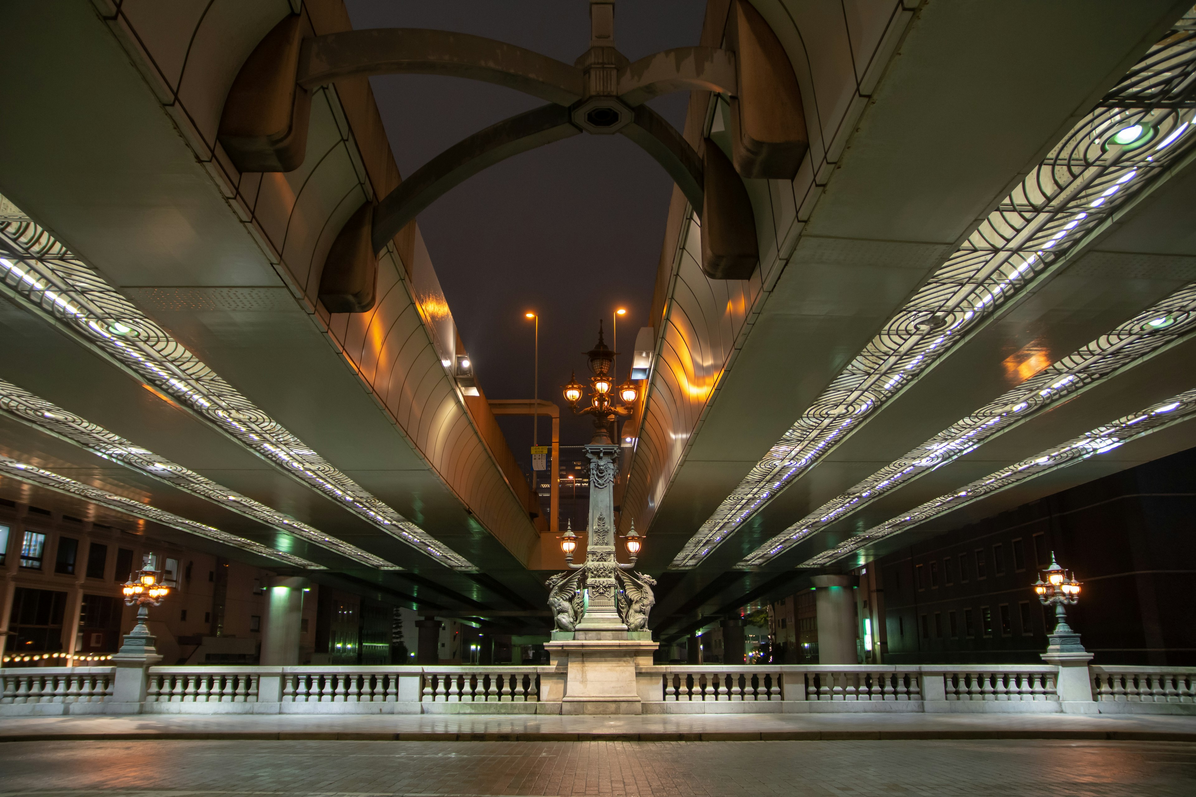 Night scene under a bridge with illuminated structures